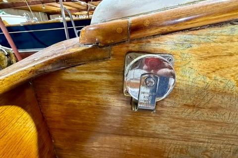 1965 Rhodes Reliant sailboat interior with vintage wood finish and metal hardware.
