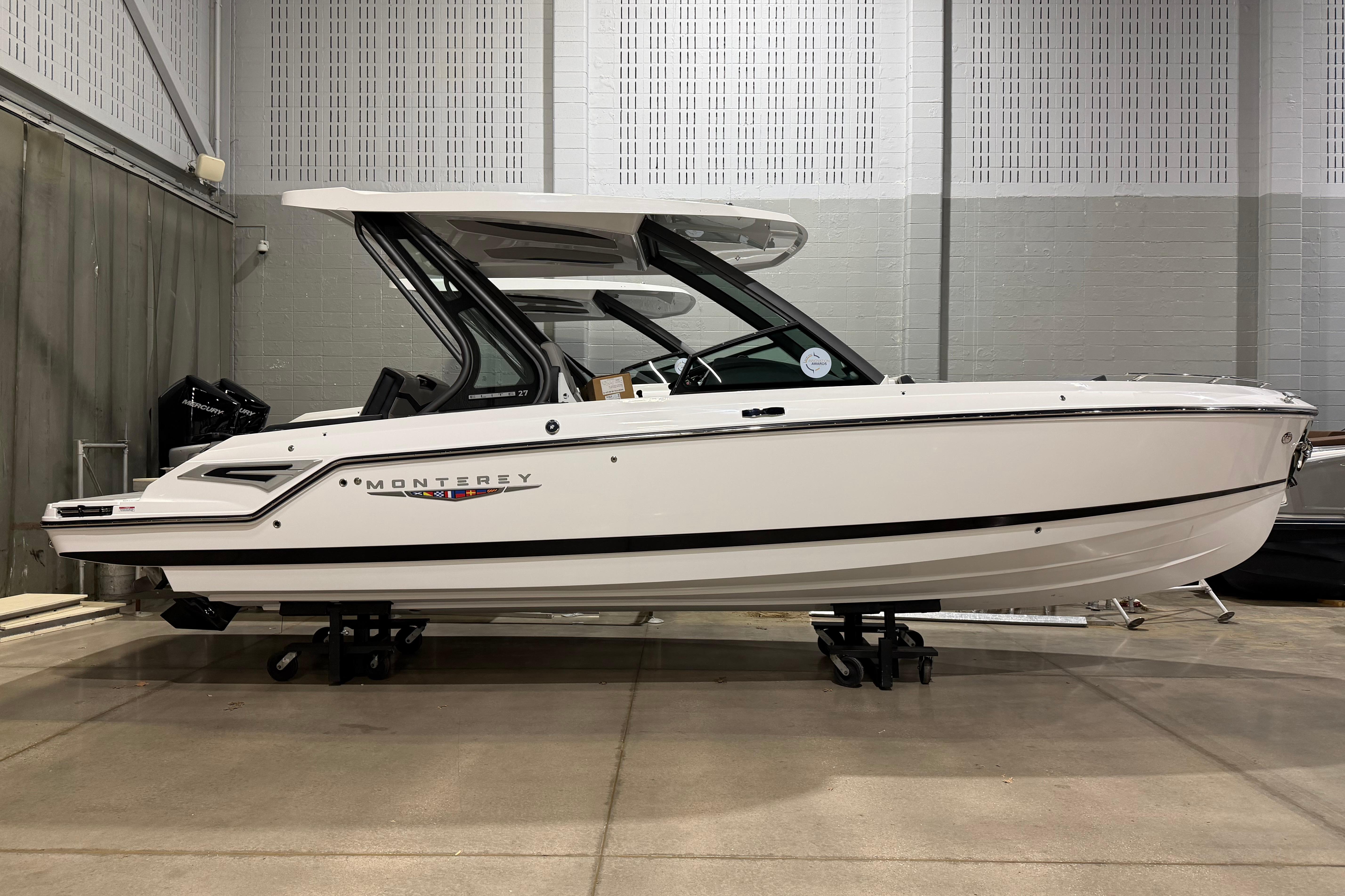 2026 Monterey Elite 27 SD boat displayed indoors on stands.