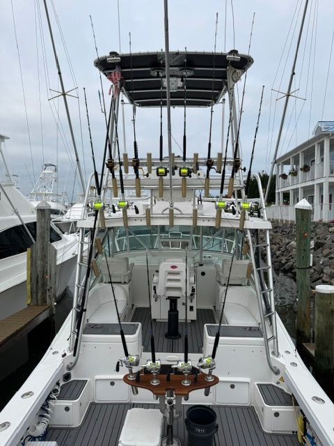 The image shows a 2005 Luhrs 32 Open boat with multiple fishing rods on the deck.