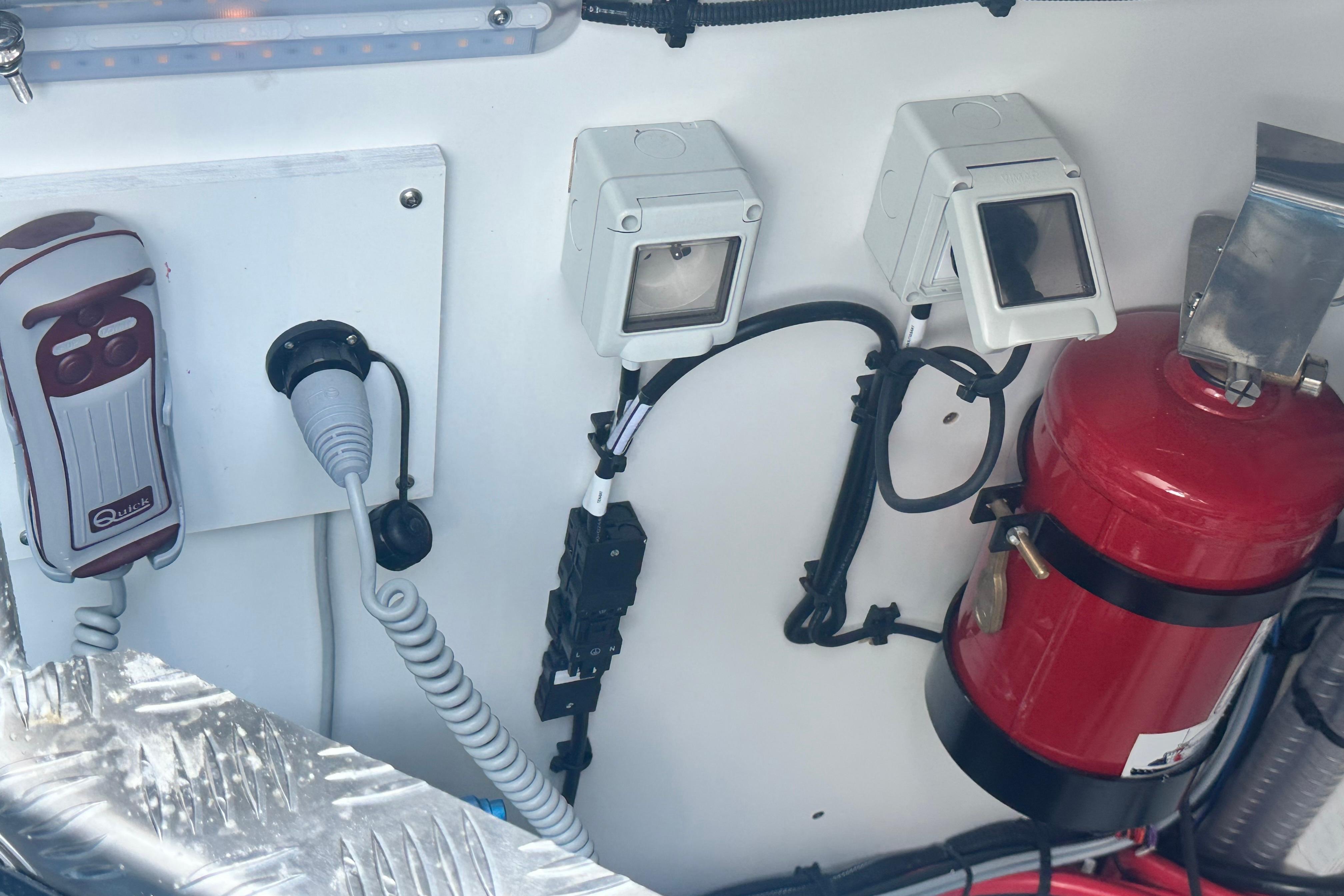 Control panel of 2025 Lagoon 55 yacht with fire extinguisher and electrical components.