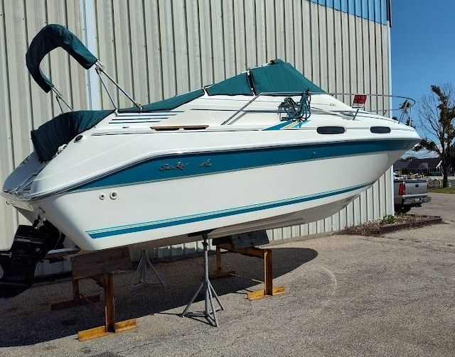 1994 Sea Ray 230 Sundancer boat elevated outside warehouse.