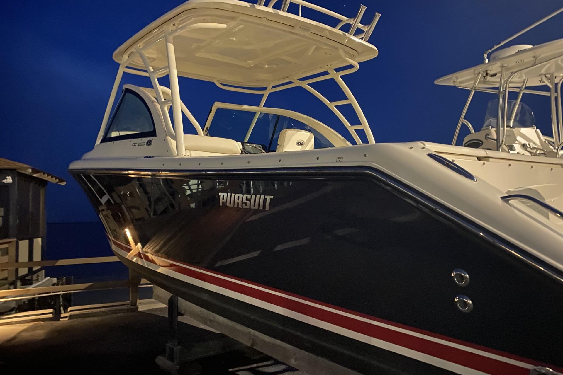 2013 Pursuit DC 265 Dual Console boat docked at night.