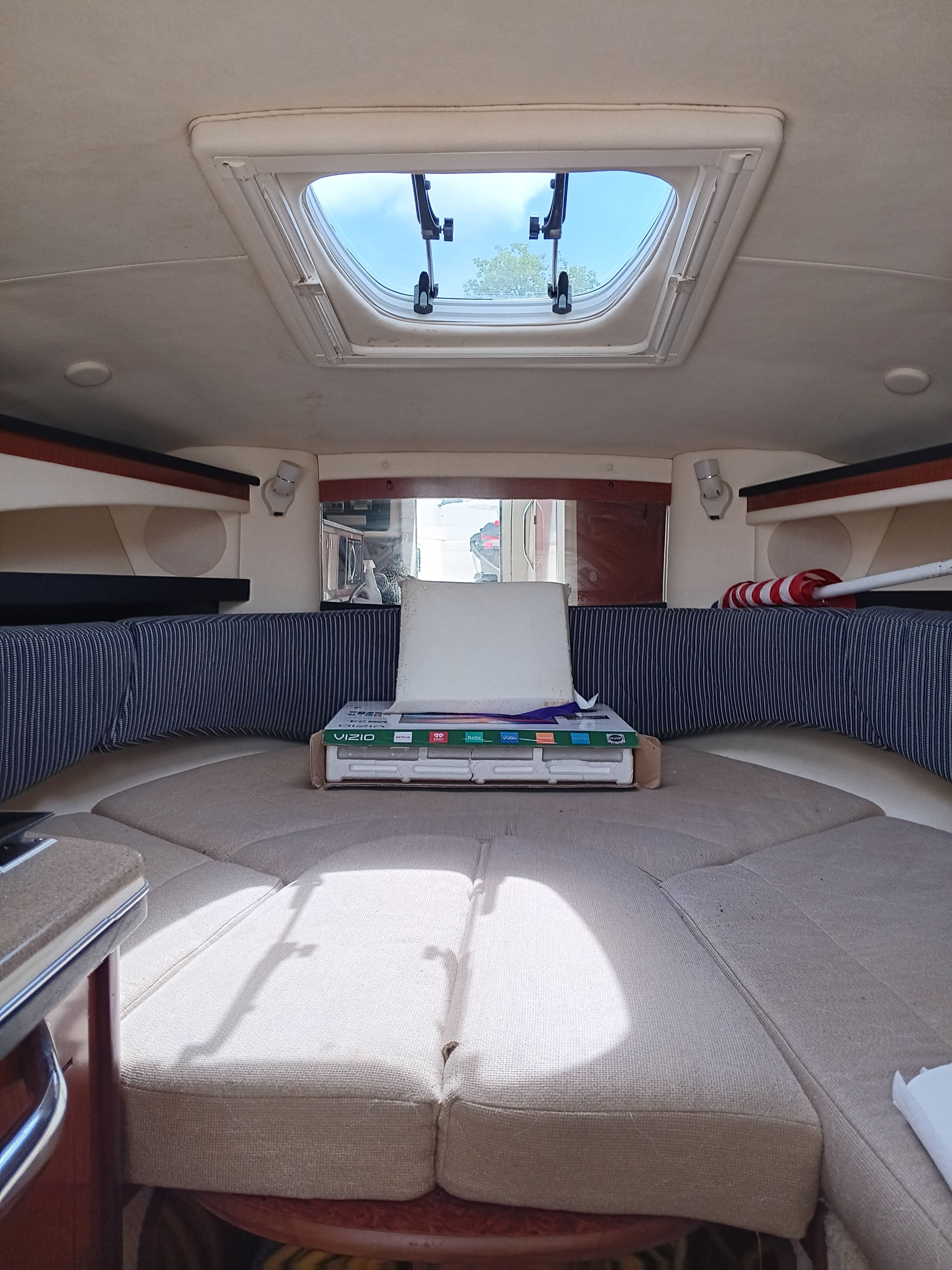 Interior of a 2005 Sea Ray 260 DA Sundancer with skylight and cushioned seating.