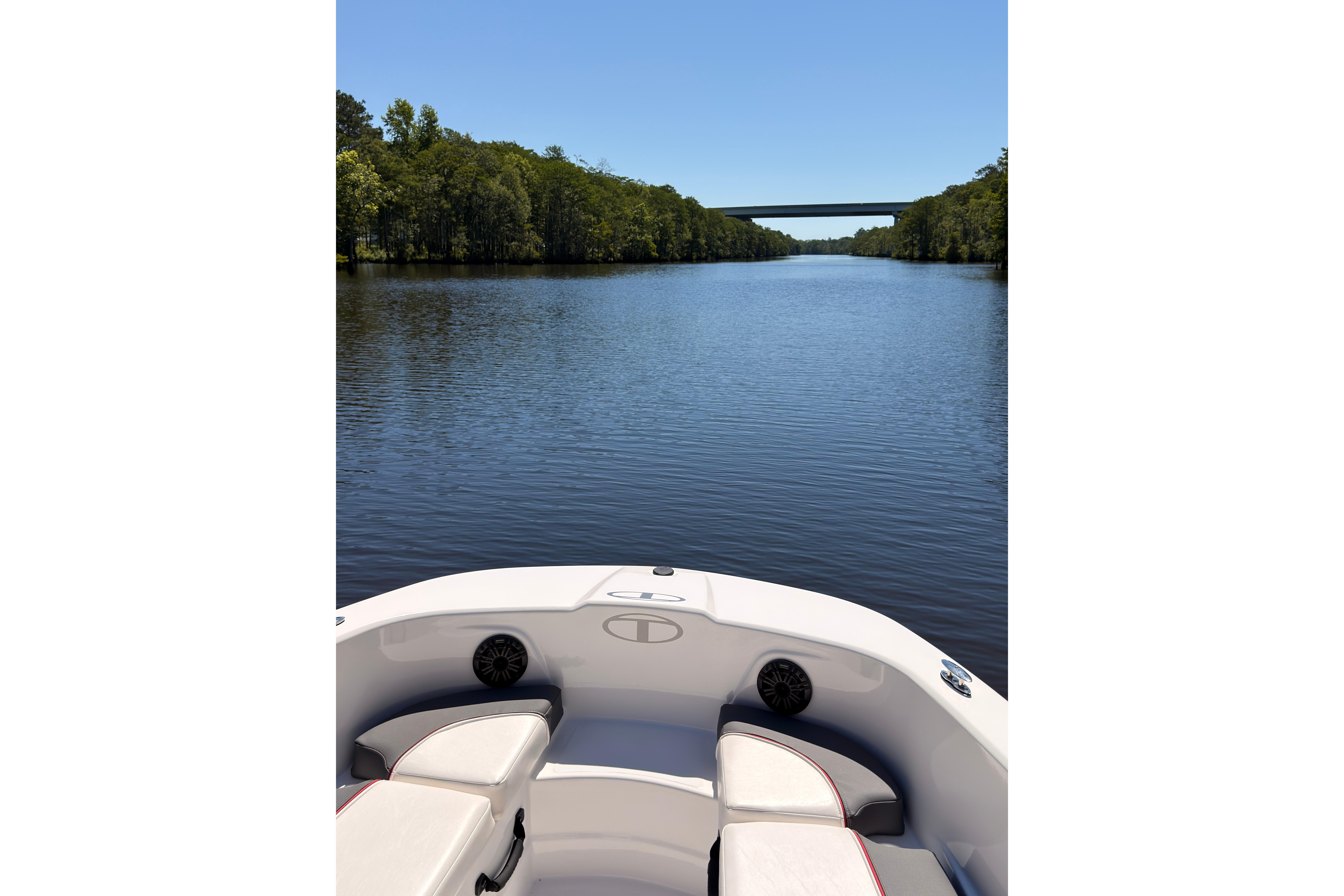 2022 Tahoe T18 boat cruising on a serene river with lush green trees.