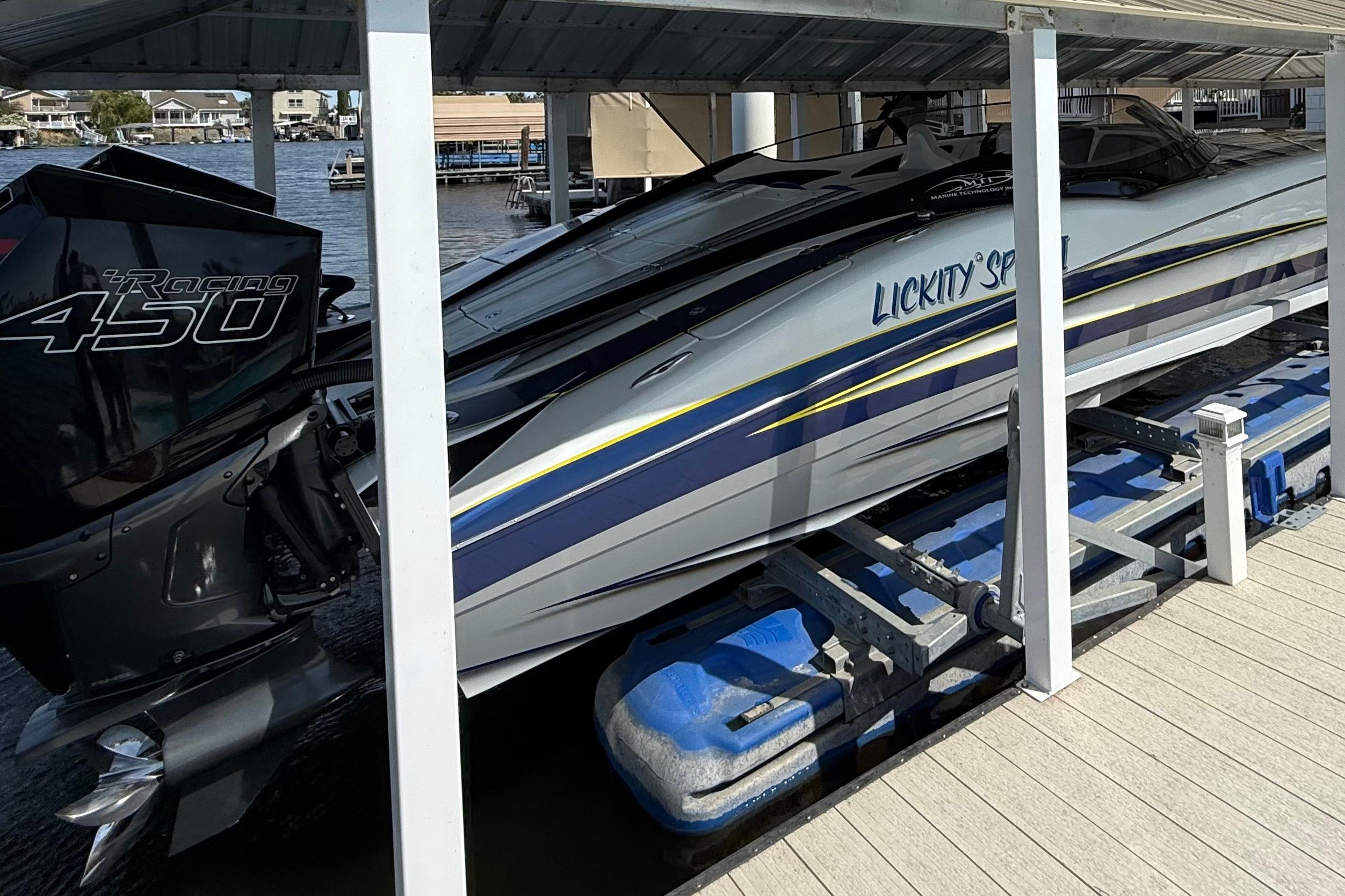 High-performance MTI 340X speedboat with Racing 450 engine docked under a covered marina.