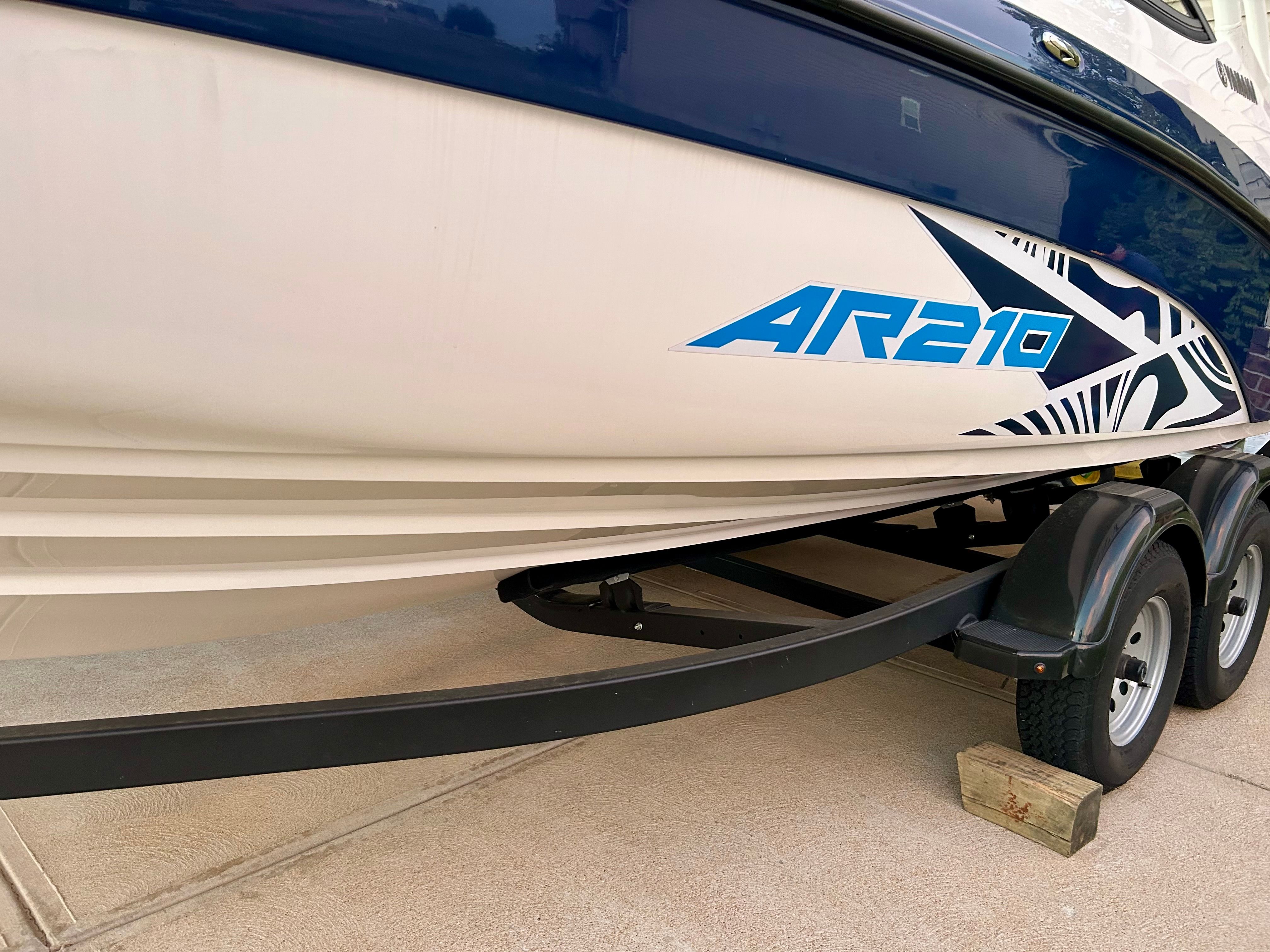 A 2022 Yamaha AR210 boat is on a trailer on a concrete surface.