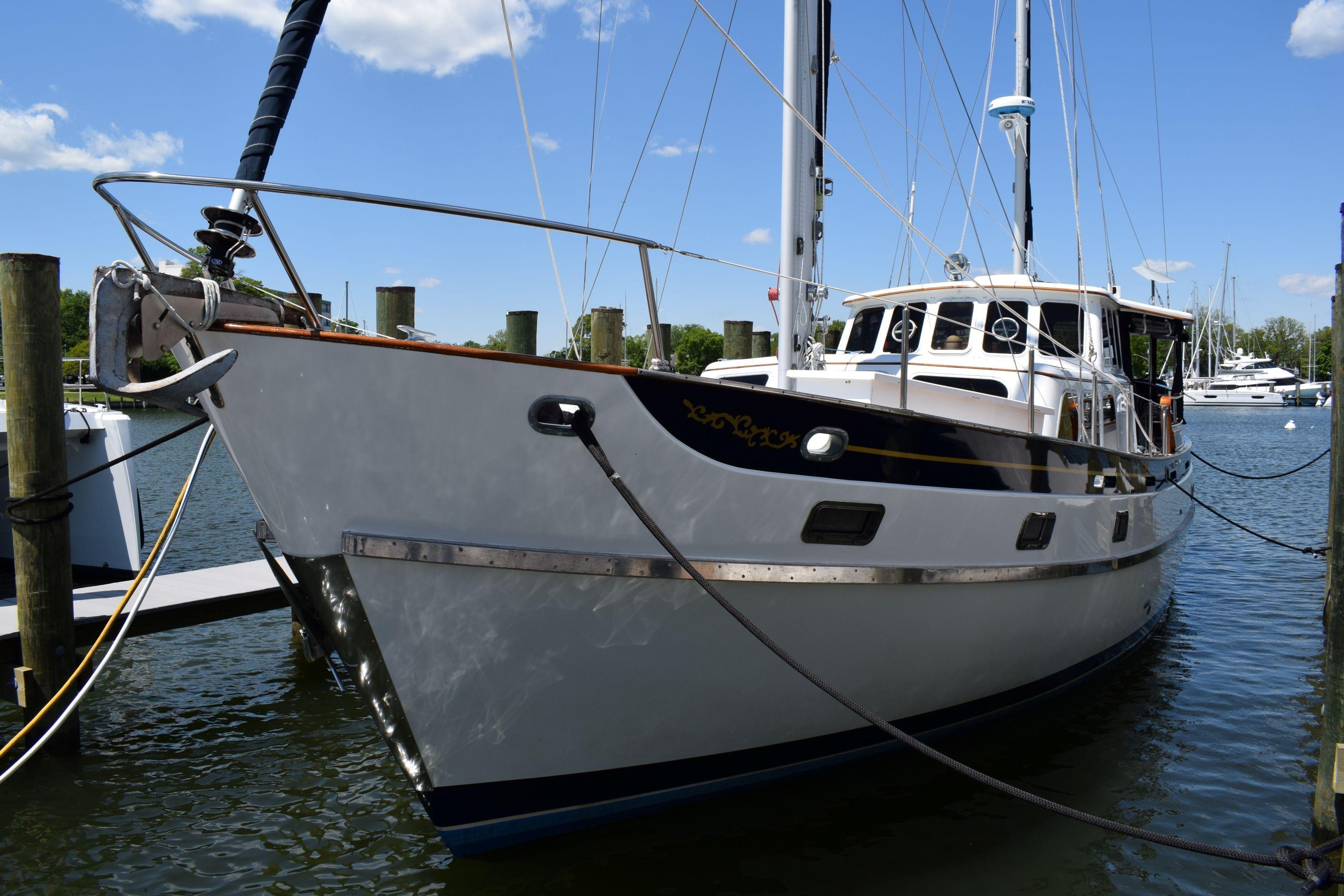 1980 Cheoy Lee 52 Motorsailer docked at marina under clear blue sky.