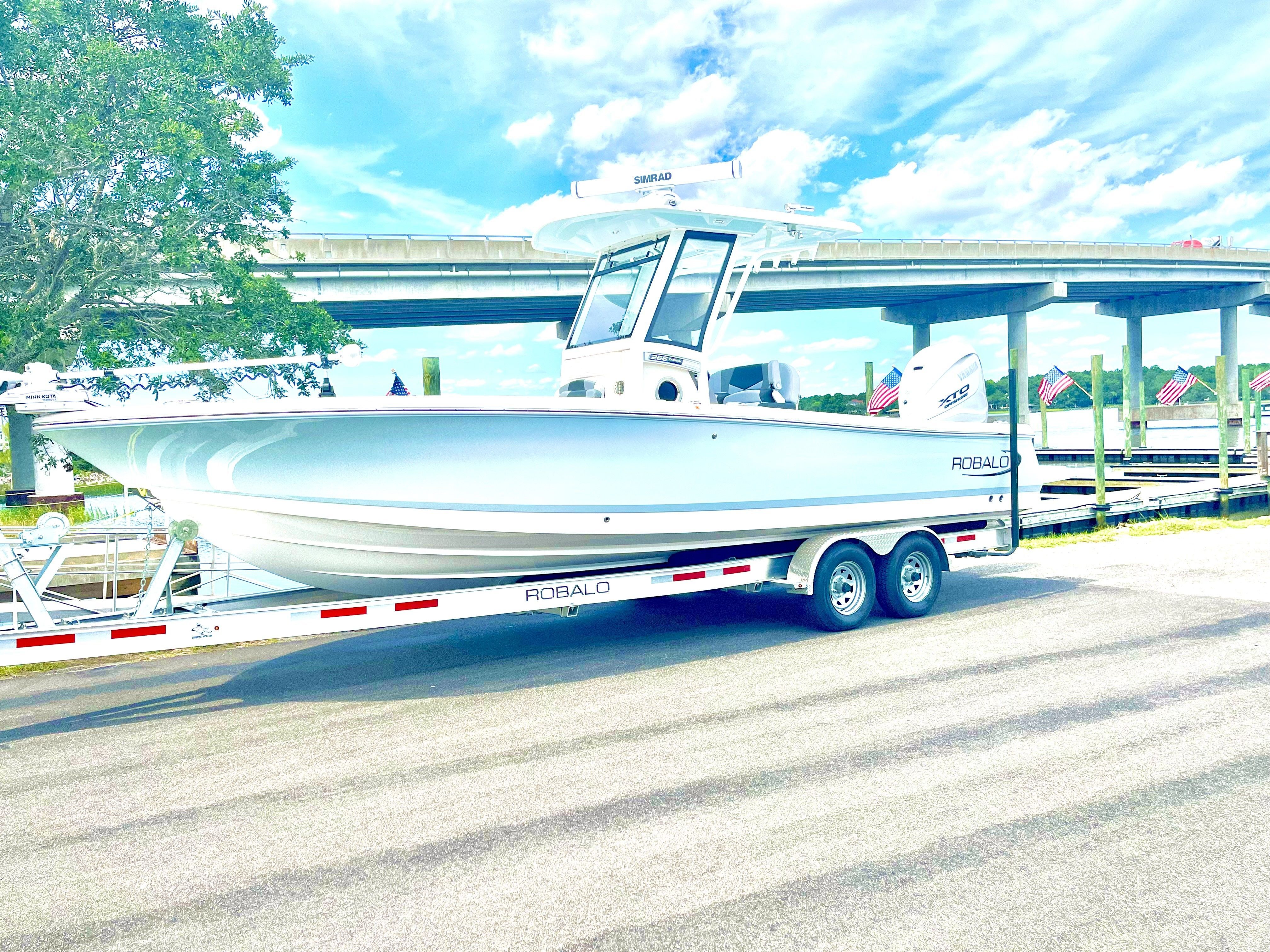 2025 Robalo 266 Cayman boat on trailer under bridge.