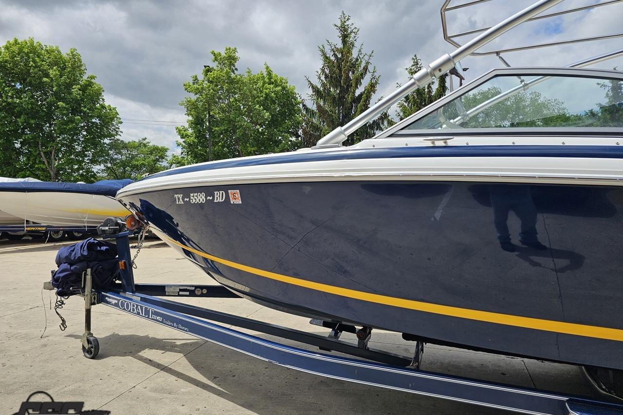 2010 Cobalt 232 WSS boat on trailer, parked outdoors with trees in background.