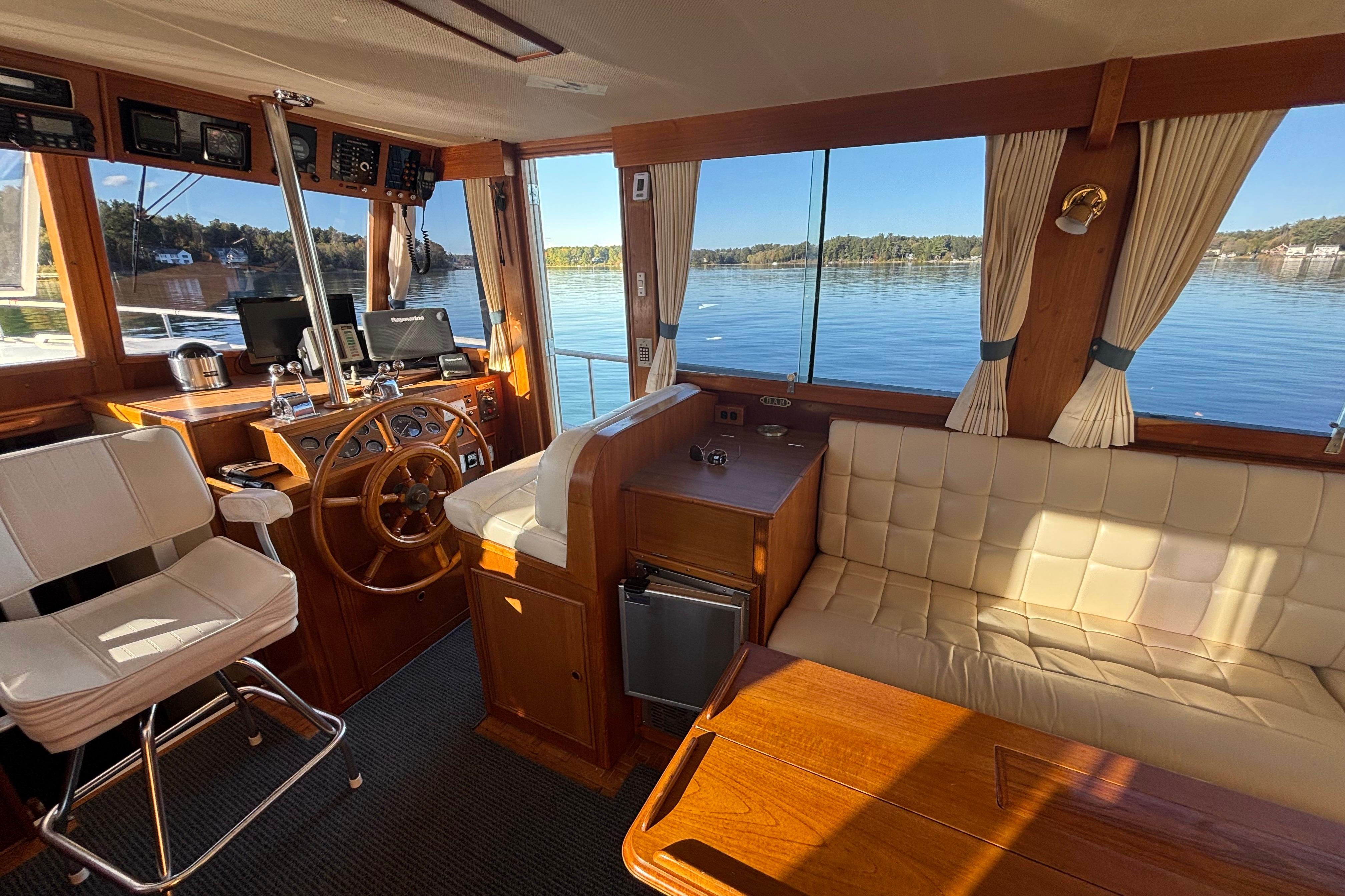 Interior of 1989 Grand Banks 46 Classic yacht with helm, seating, and scenic water view.