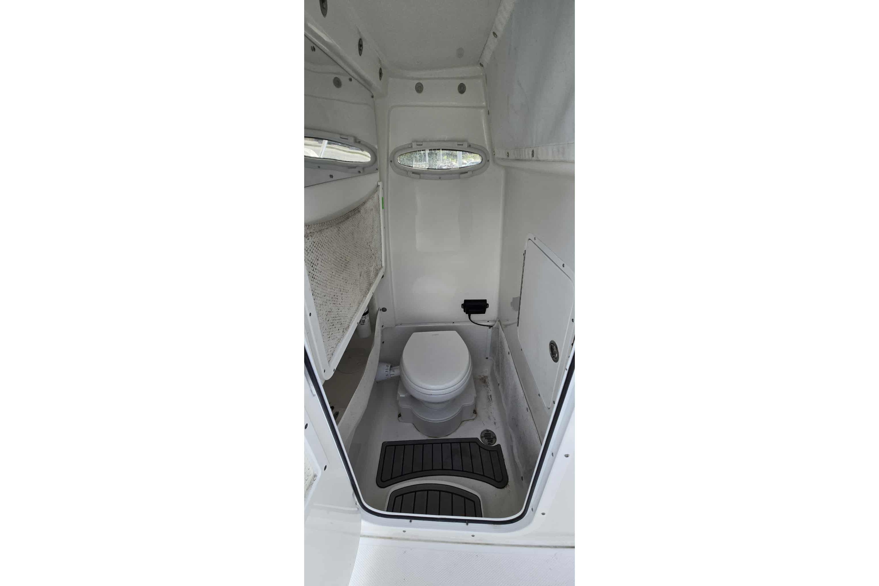2024 Sea Hunt Gamefish 27 Coffin Box boat interior with compact marine toilet.