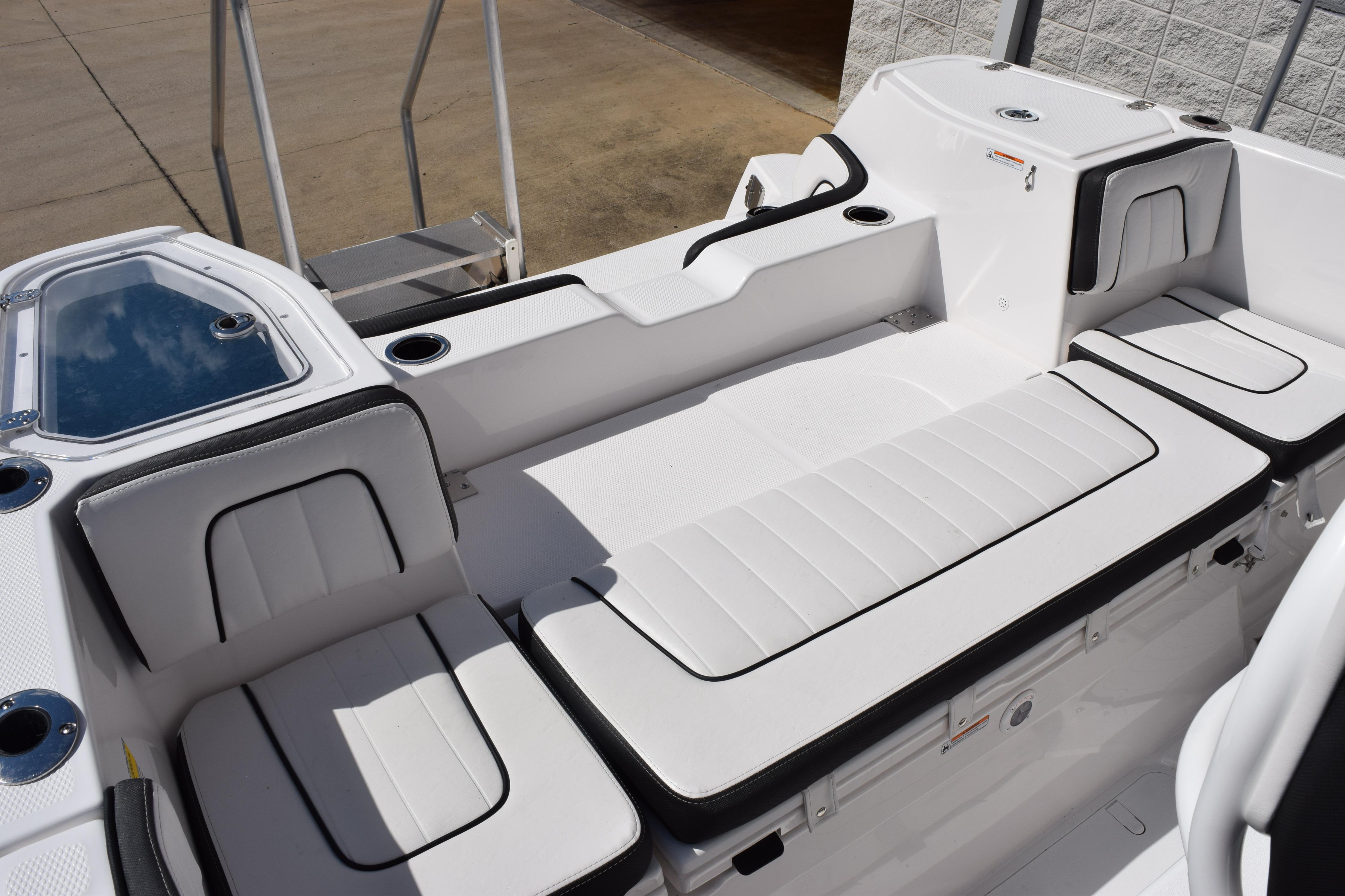 2026 Yamaha Boats 255 FSH Sport H interior with white cushioned seating and cup holders.