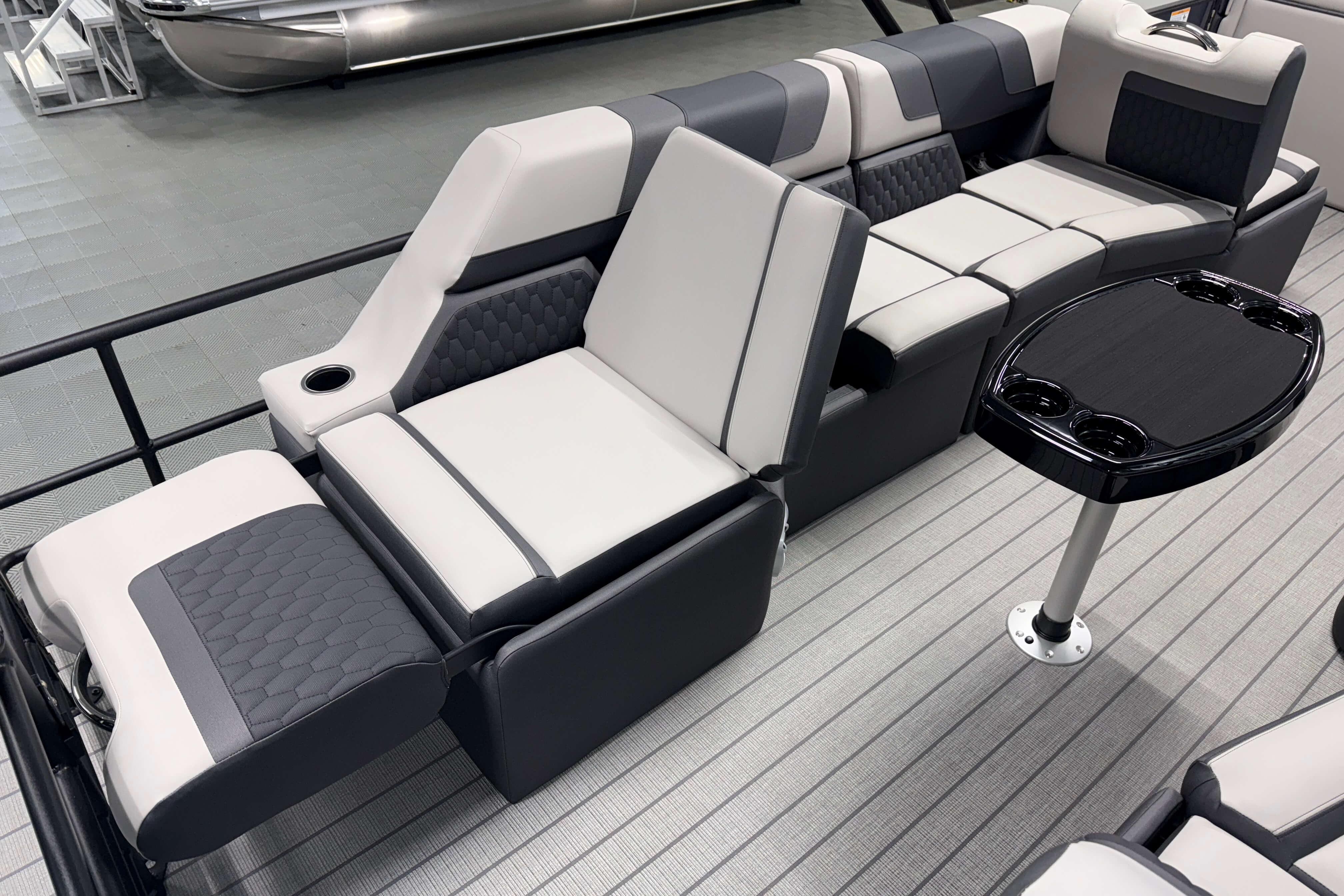 Luxurious seating on 2026 Sylvan L3 SLZ pontoon boat with sleek design and cup holders.