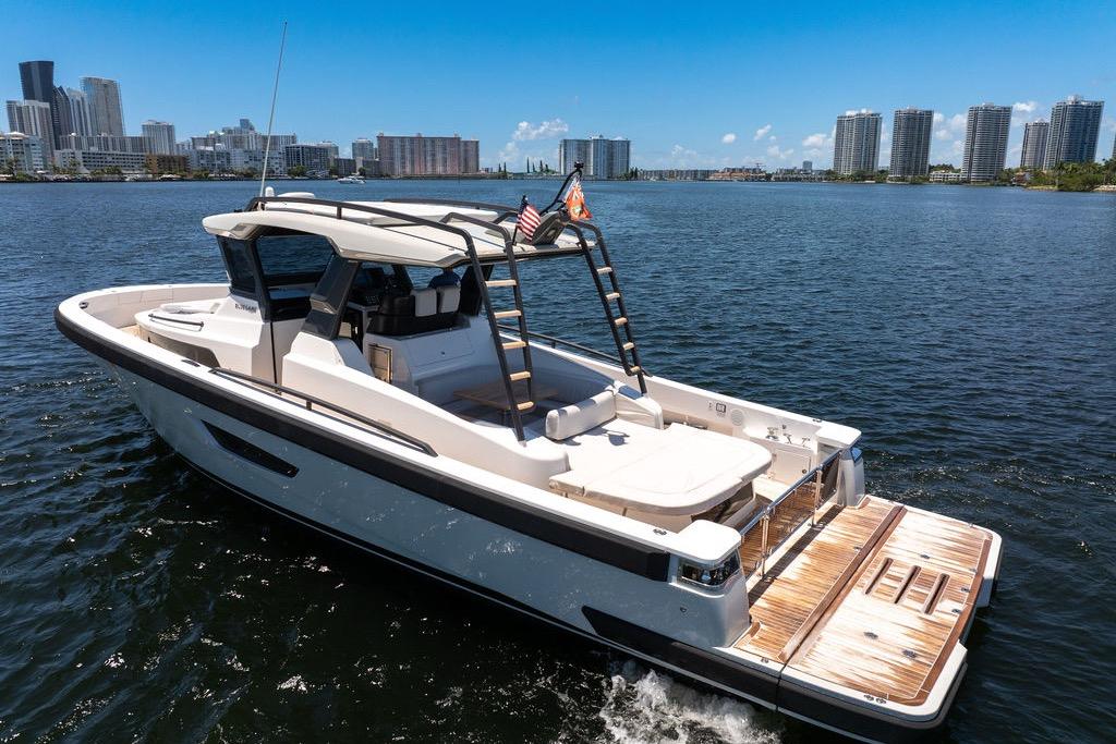 2021 Bluegame BG 42 yacht cruising near city skyline on a sunny day.