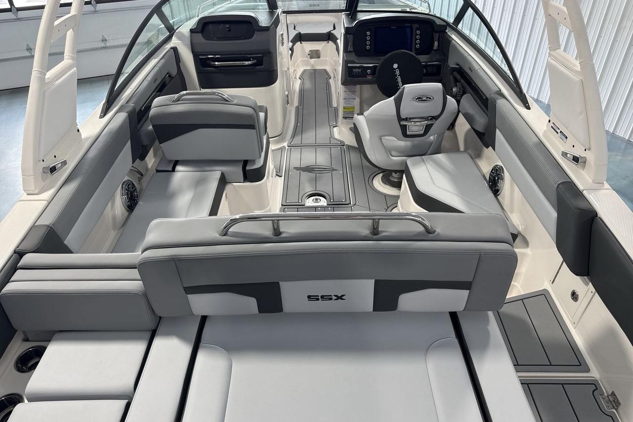 Interior of a modern boat with gray seating and a helm station.