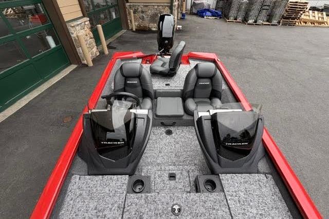 2026 Tracker Pro Team 175 boat with dual seats and modern dashboard, parked outdoors.