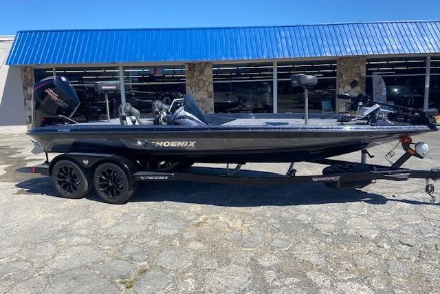2026 Phoenix 921 ELITE boat with trailer, parked outside a building with a blue roof.