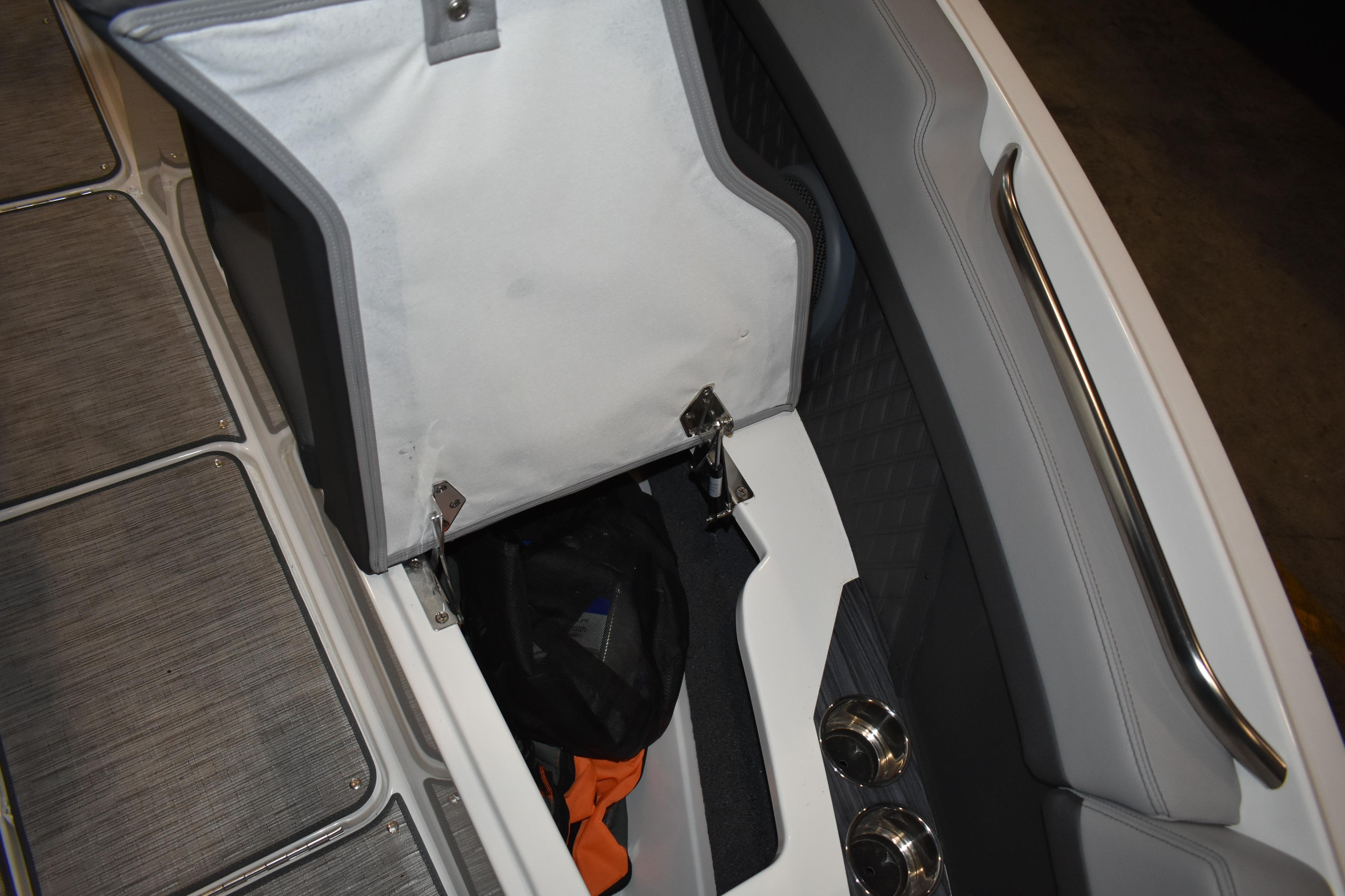 2023 Cobalt R8 boat storage compartment with open lid and visible interior items.