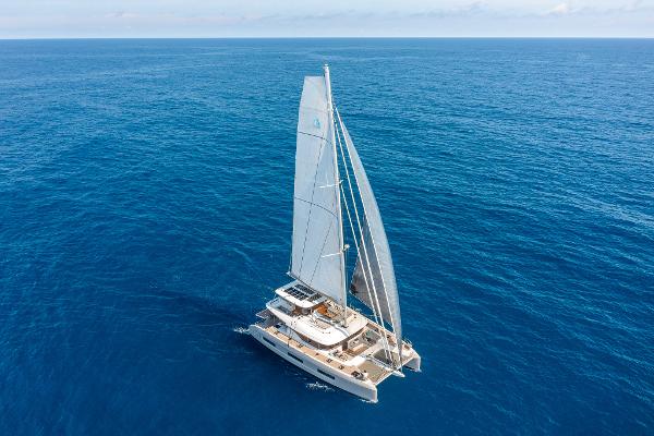 2025 Lagoon 60 catamaran sailing on open ocean under clear skies.