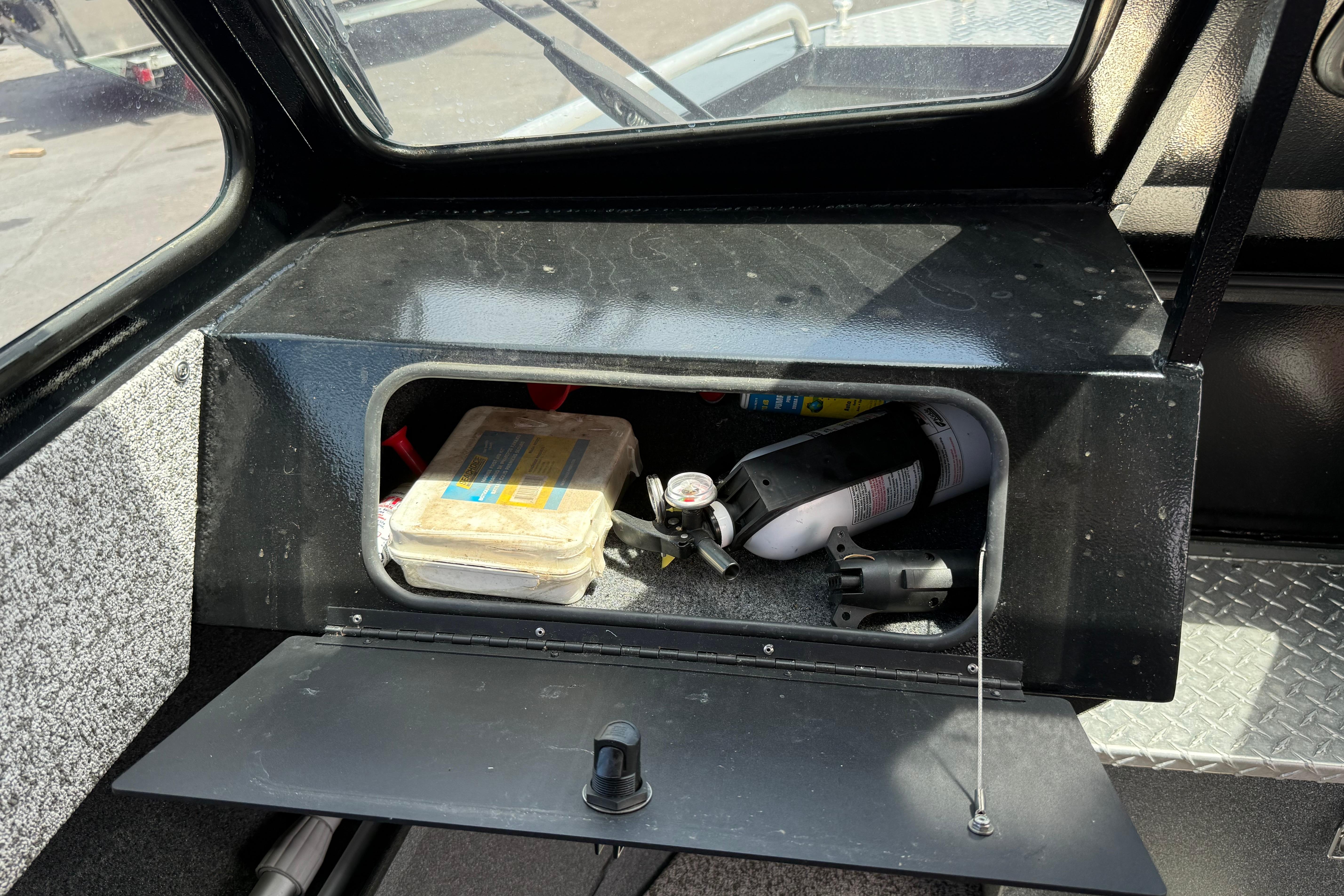 Storage compartment in a 2019 Alumaweld Intruder Hard Top 22' boat with safety equipment.