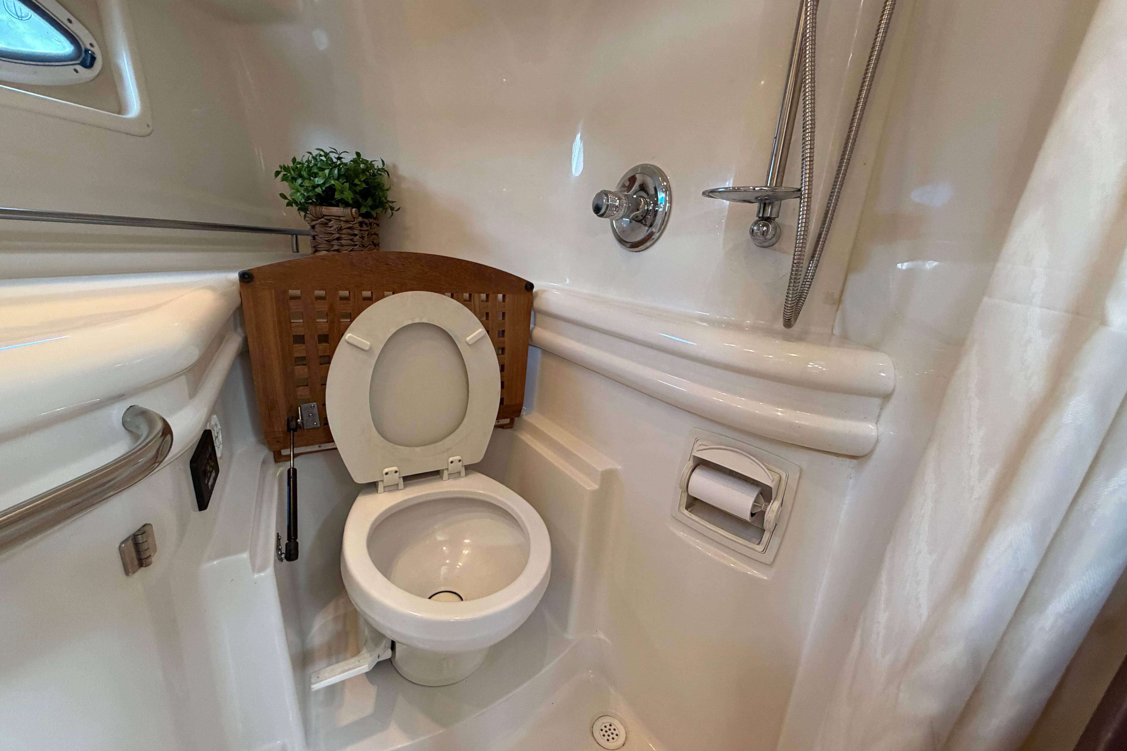 2007 Monterey 350 Sport Yacht bathroom with toilet, shower, and porthole window.