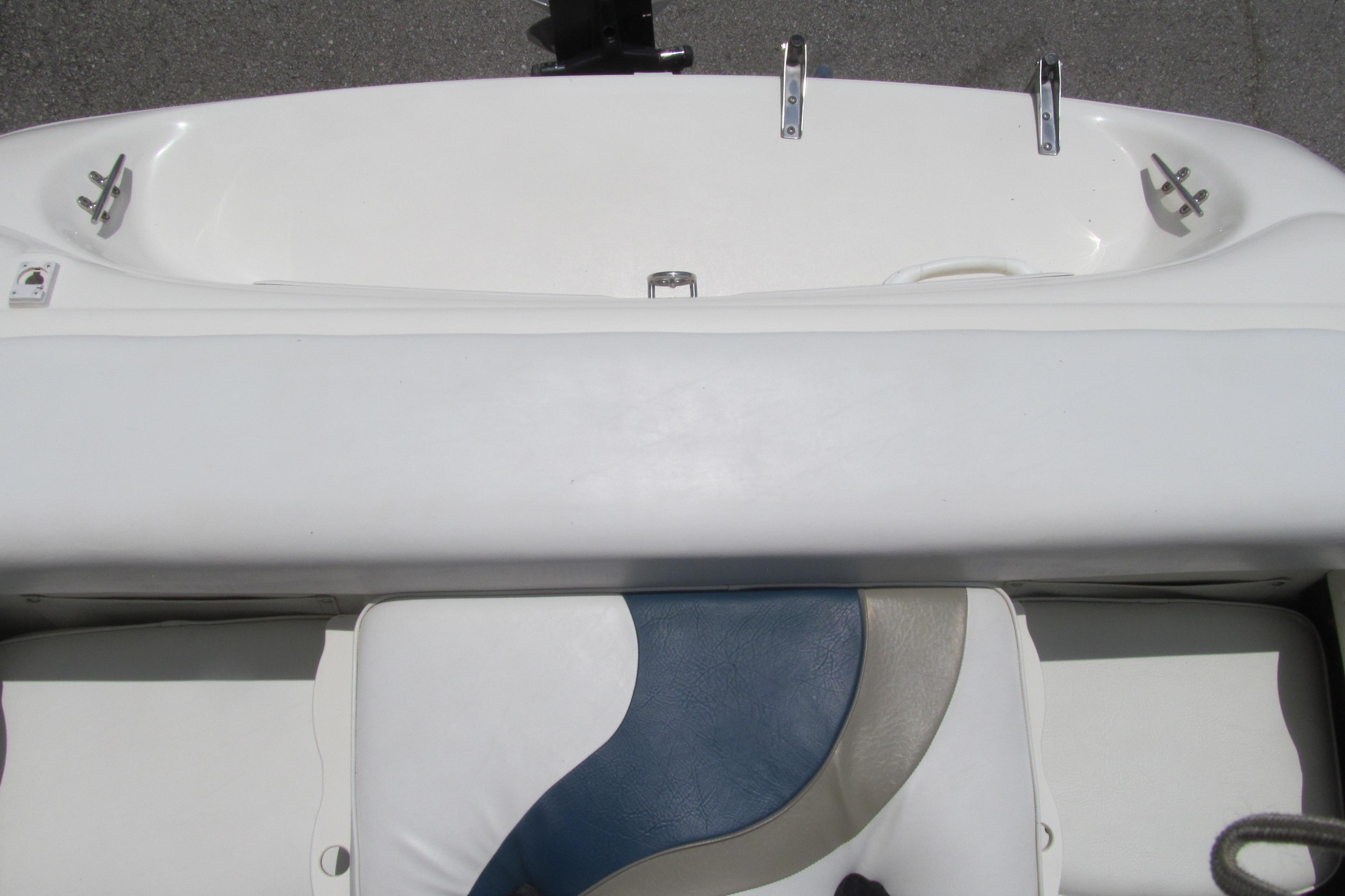2000 Rinker boat interior with white and blue seating, featuring stainless steel fixtures.