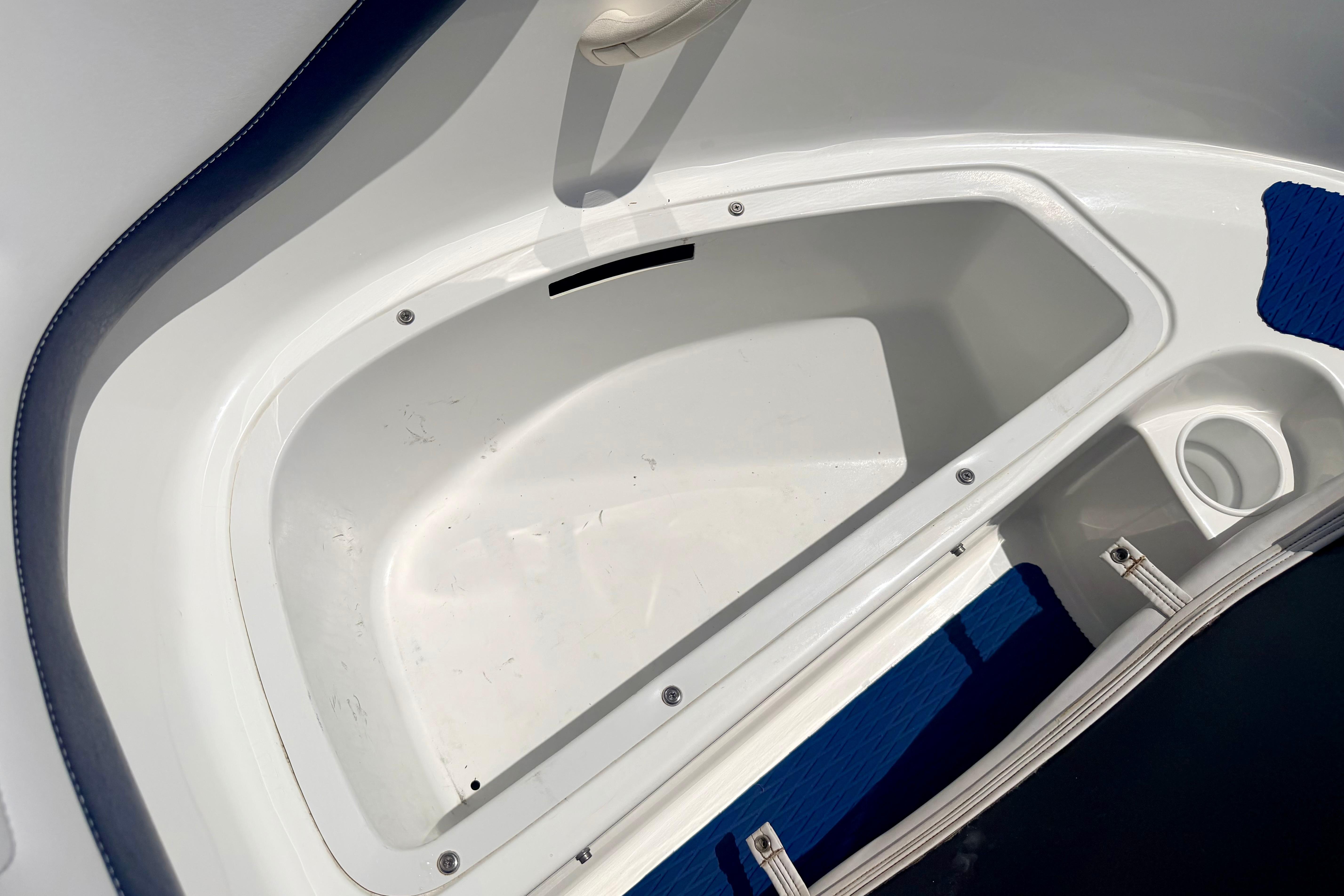 Storage compartment of a 2004 Bombardier SEADOO Utopia 185 boat, featuring white and blue interior.
