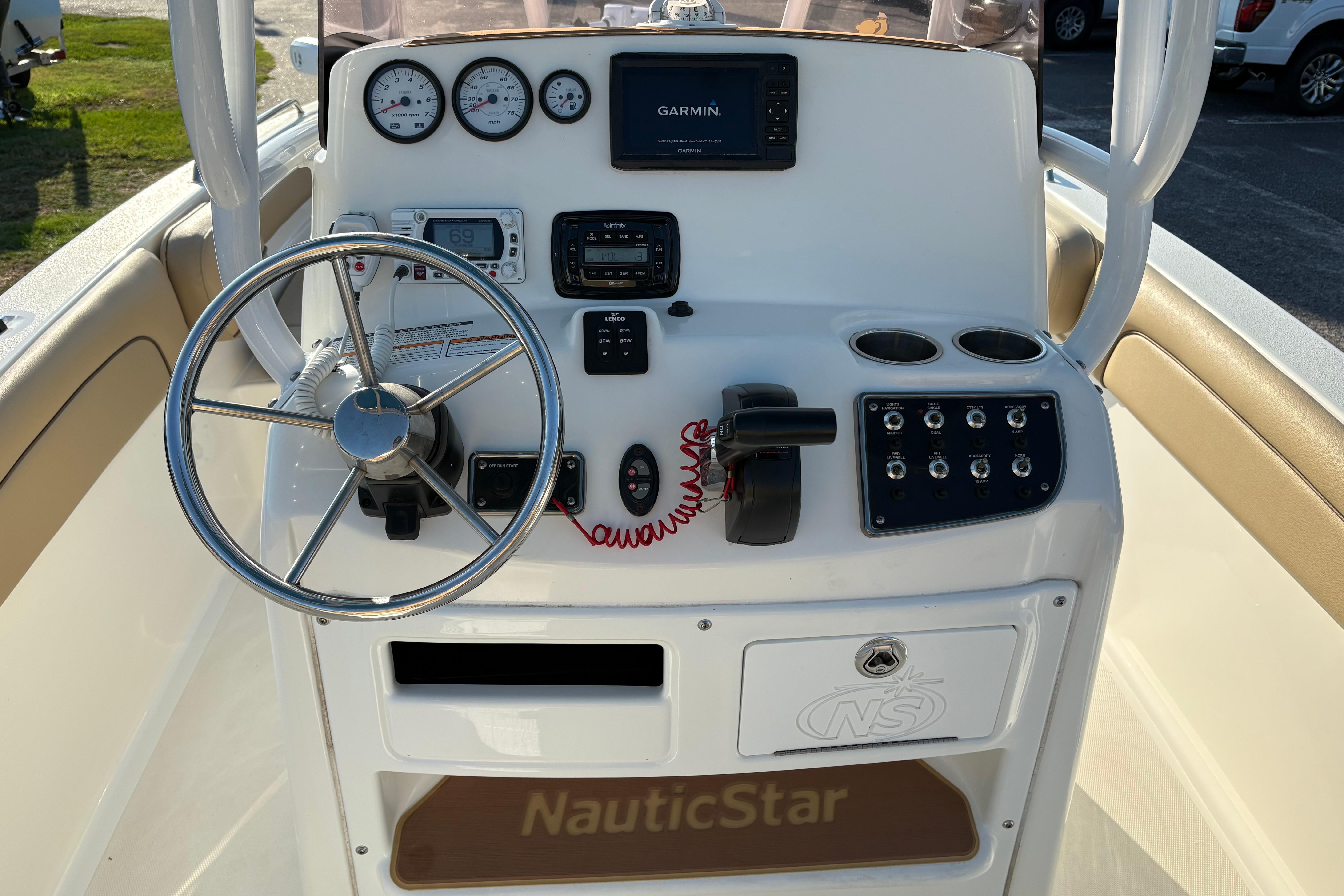 2019 NauticStar 231 Hybrid boat dashboard with steering wheel and navigation controls.