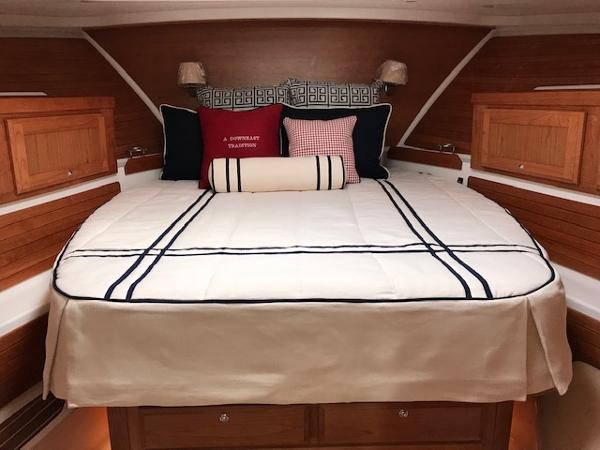 Luxurious cabin interior of 2026 Back Cove 372 yacht with elegant bedding and wooden accents.