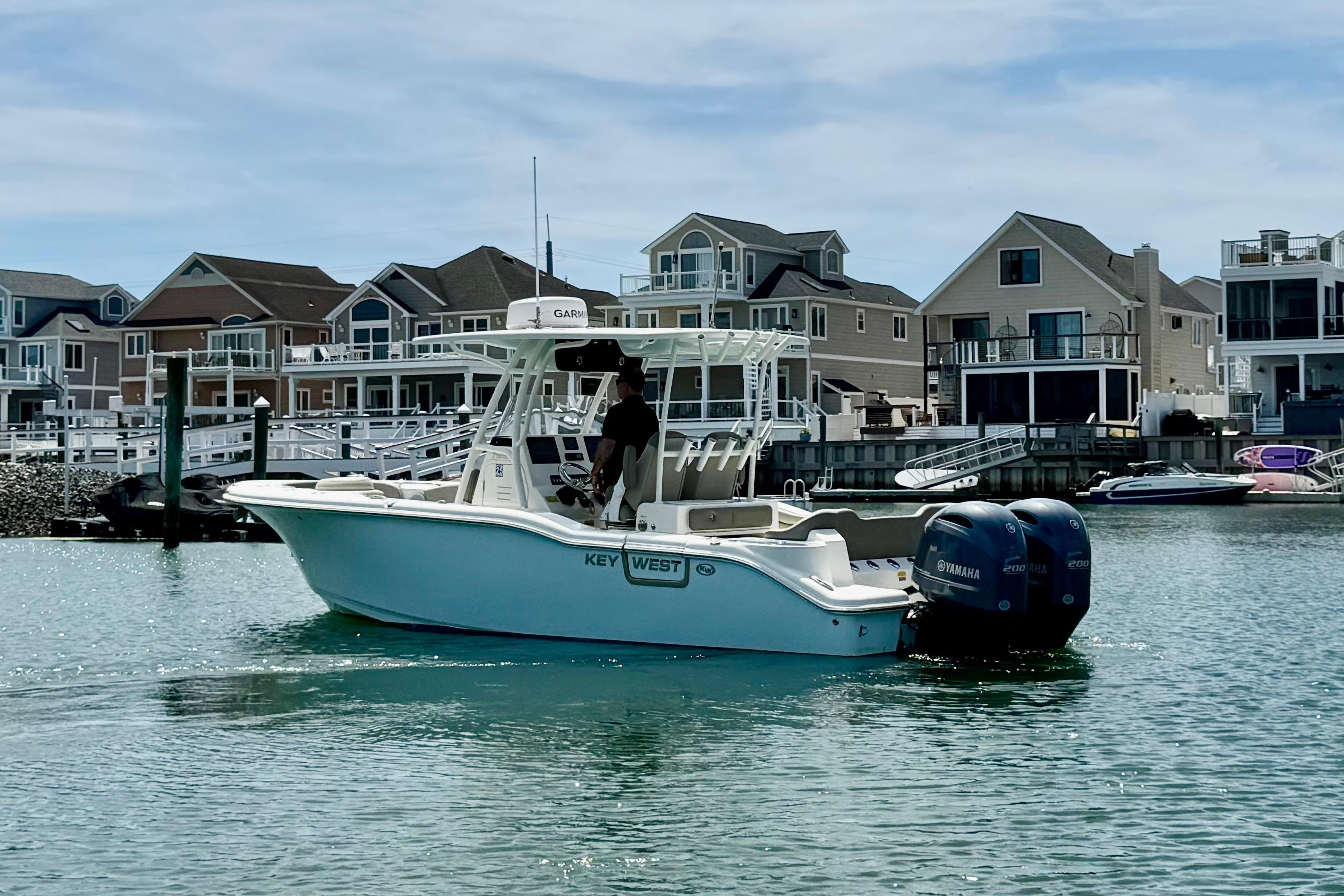 2022 Key West 263 FS boat on water near waterfront homes, featuring twin Yamaha engines.