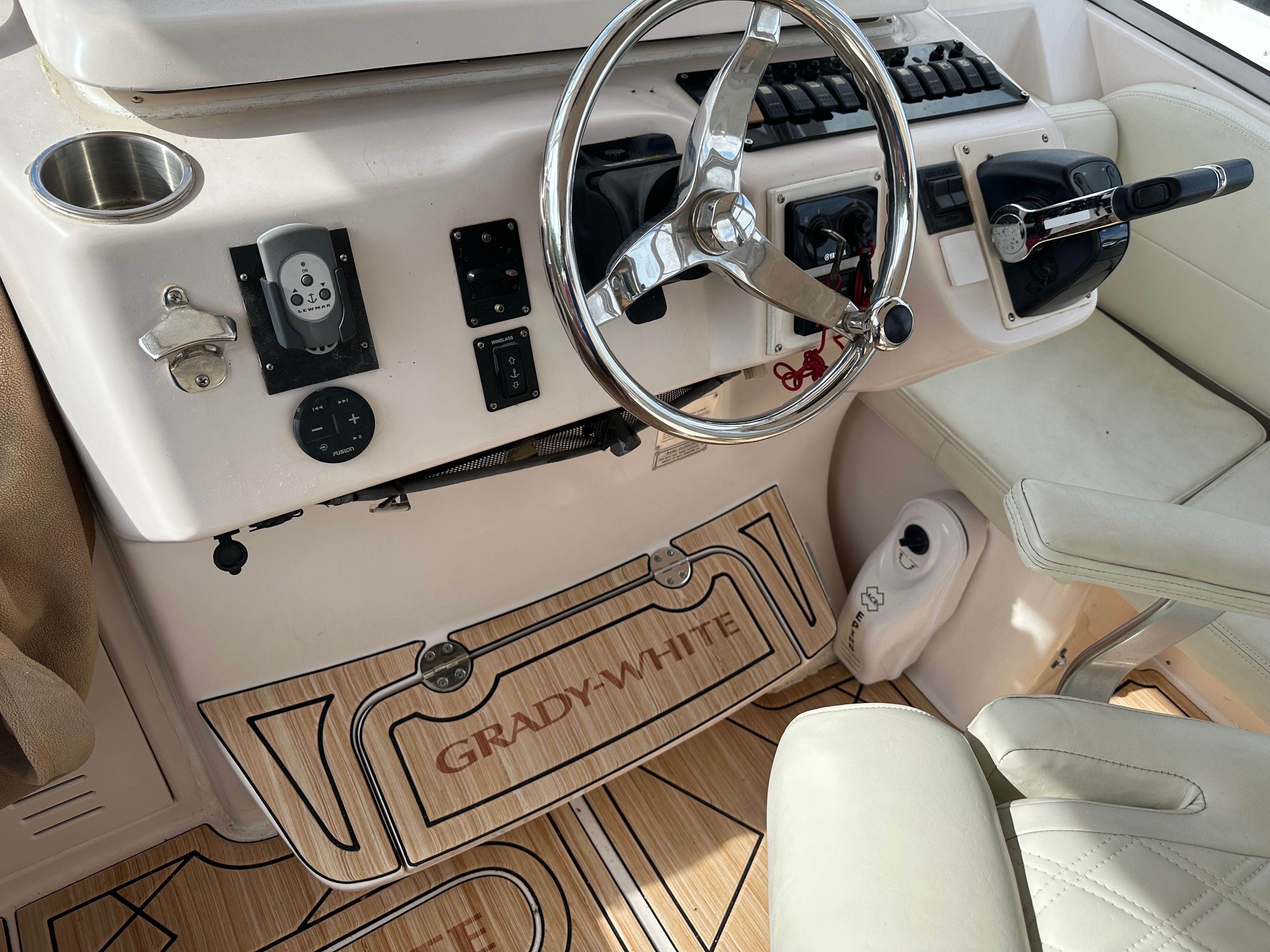 The cockpit of a 2003 Grady-White Express 330 with steering wheel, instruments, and beige seating.