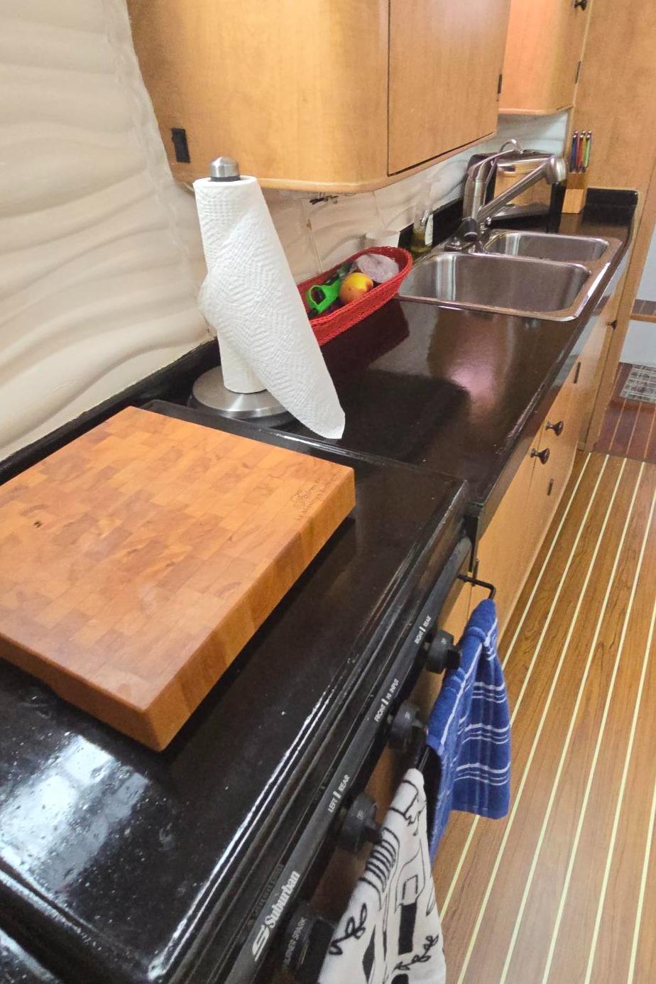 Modern kitchen interior of 2013 Kelsall Suncat 40 yacht with sleek countertops and wooden cabinetry.