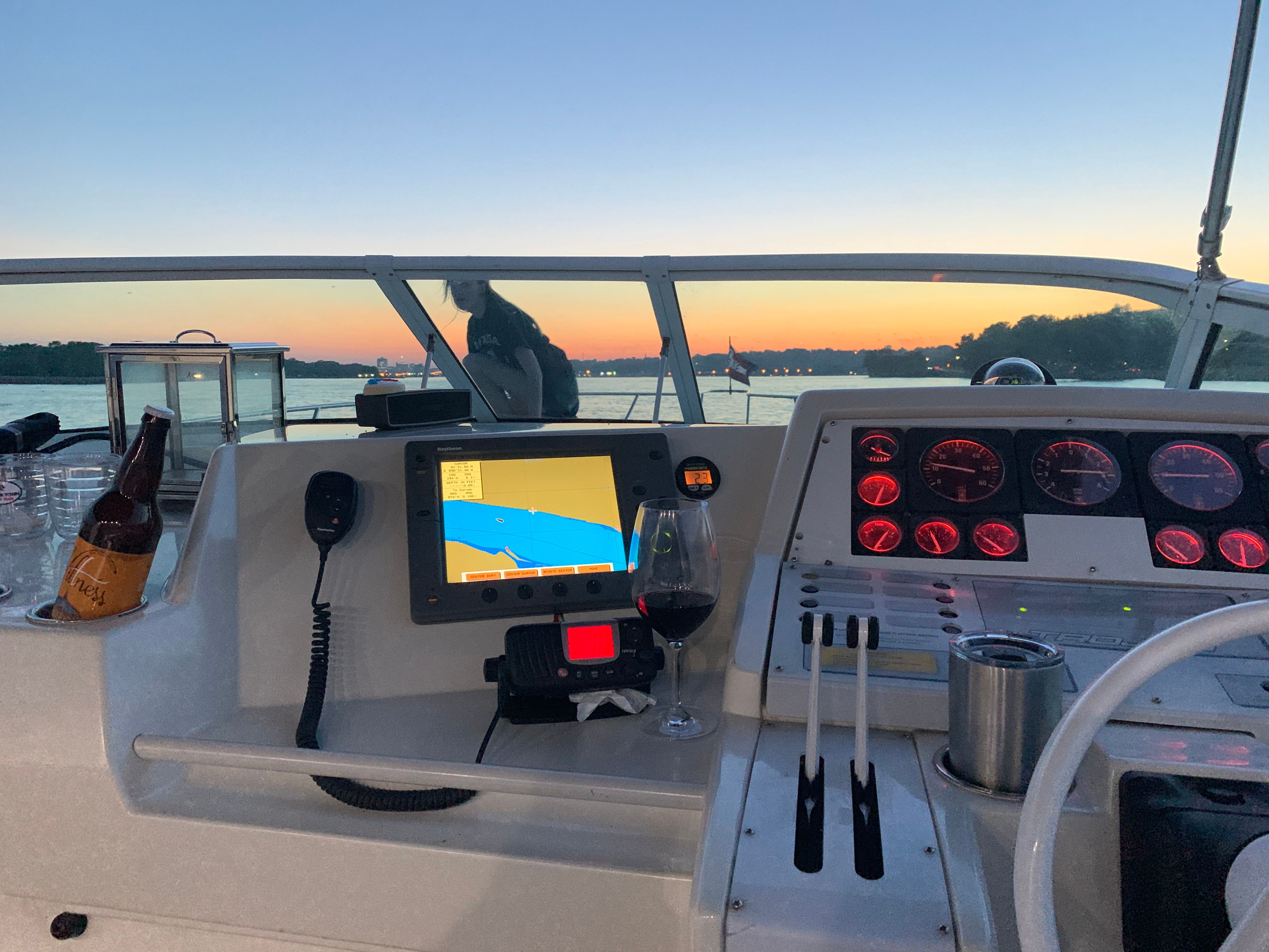 The cockpit of a 1995 Trojan 390x with navigation system and drinks at sunset.