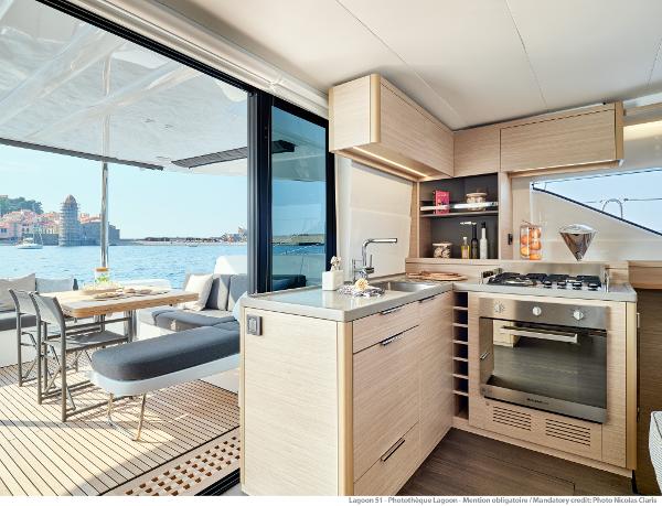 Modern kitchen interior of 2025 Lagoon 51 ICONIC yacht with ocean view.