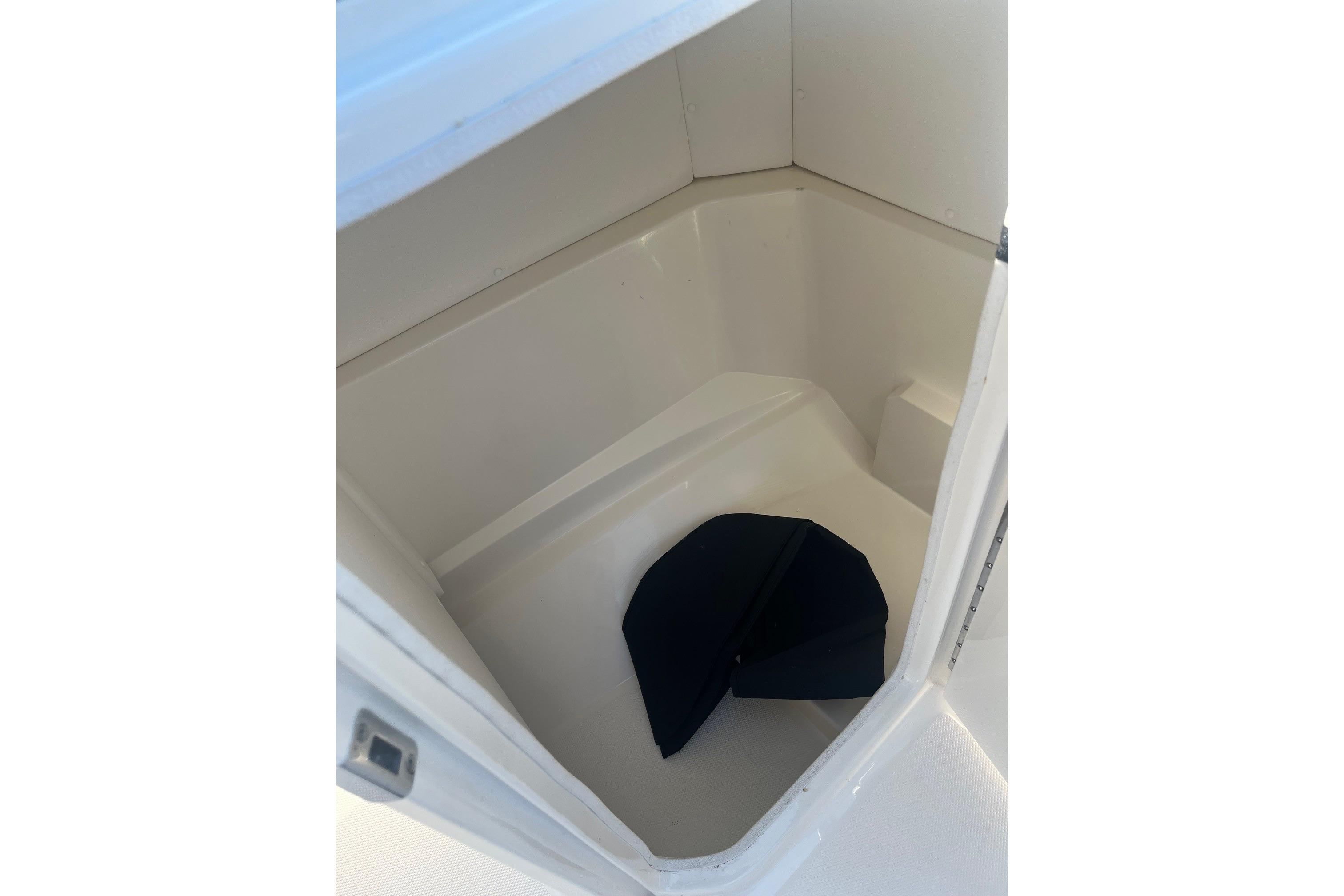 2024 Sea Ray SPX 230 storage compartment with a dark cushion inside.