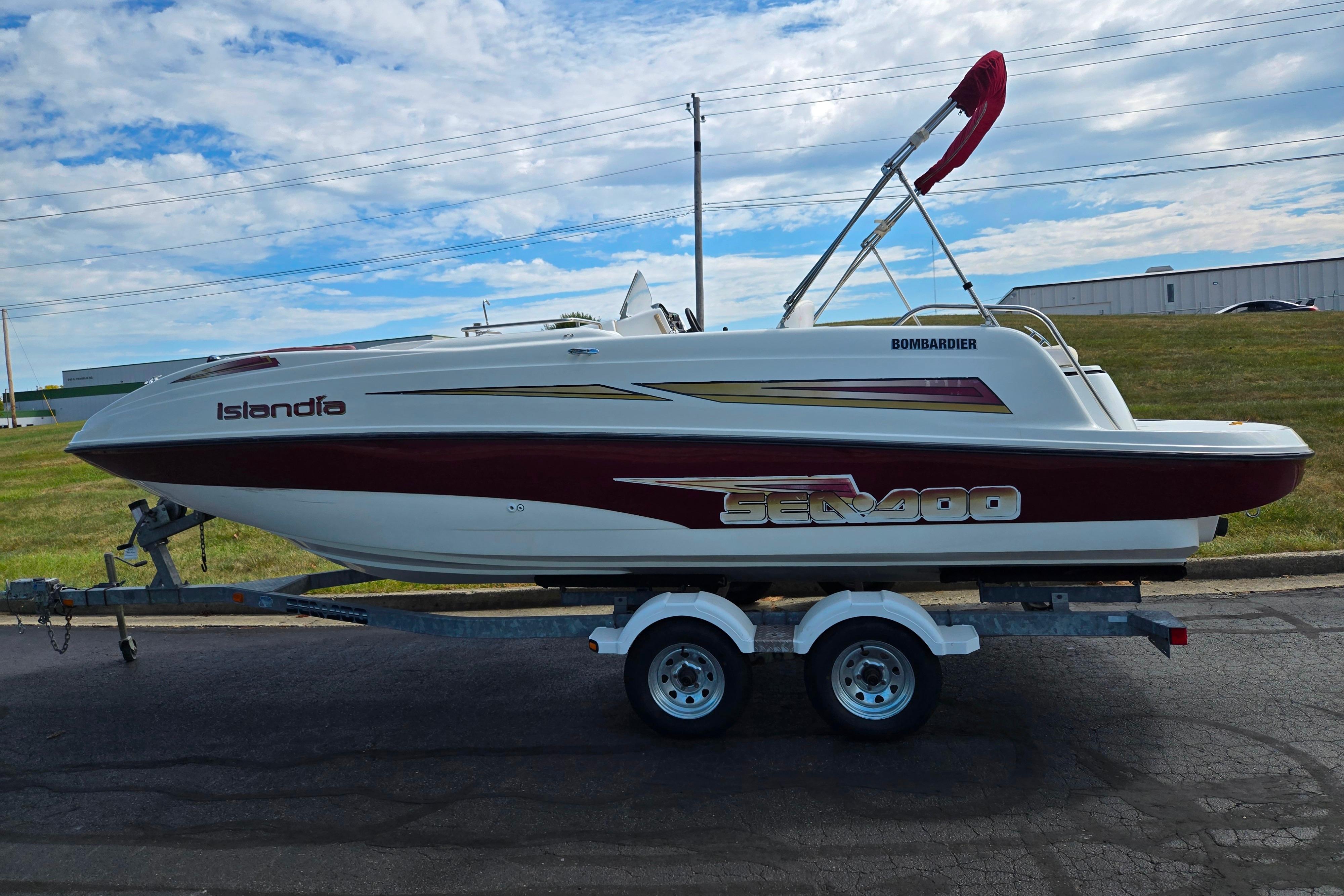 2004 Sea-Doo Islandia sport boat on trailer, parked outdoors under a cloudy sky.