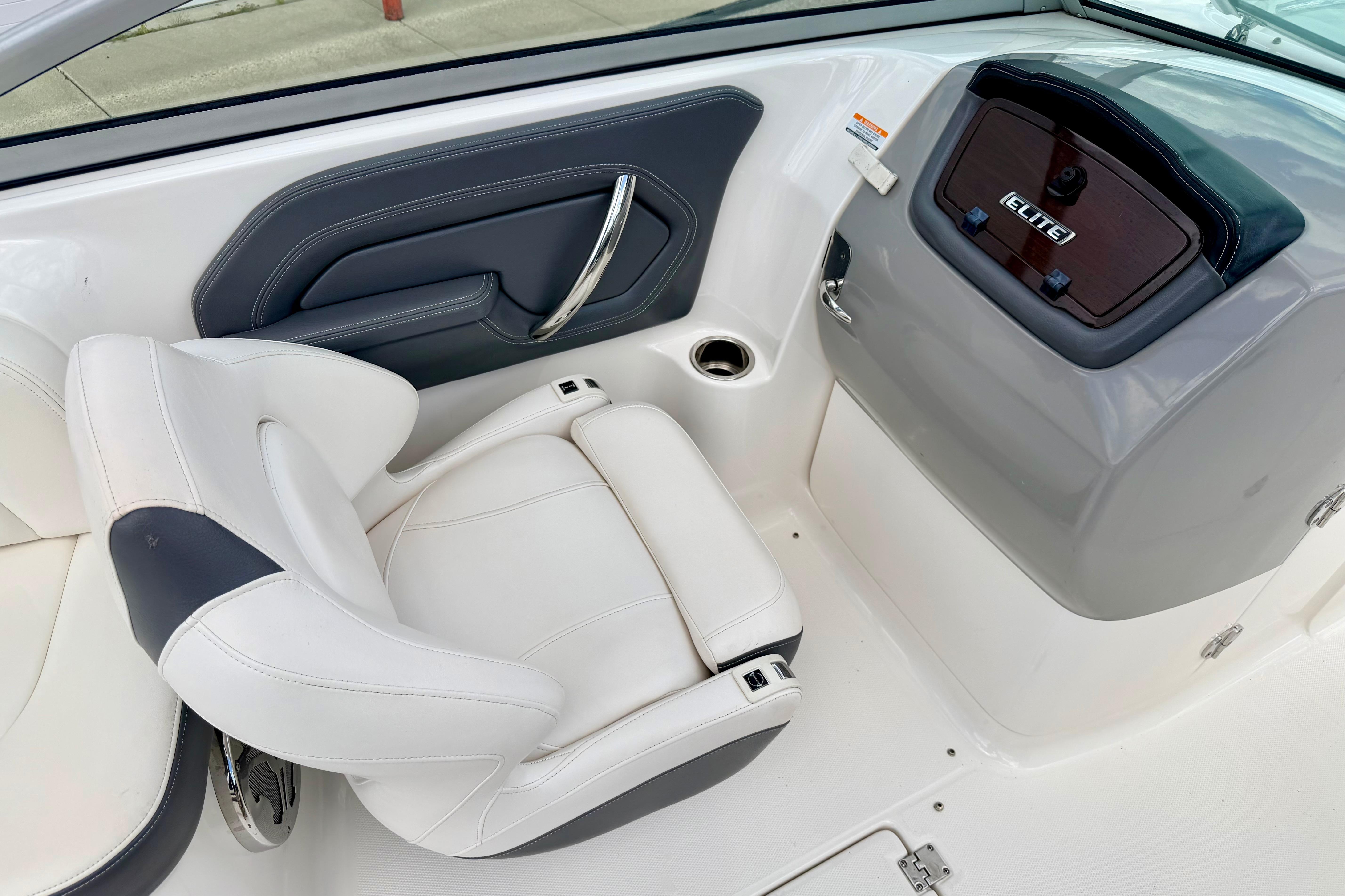 2015 Chaparral Sunesta 264 boat interior with white seating and sleek dashboard design.