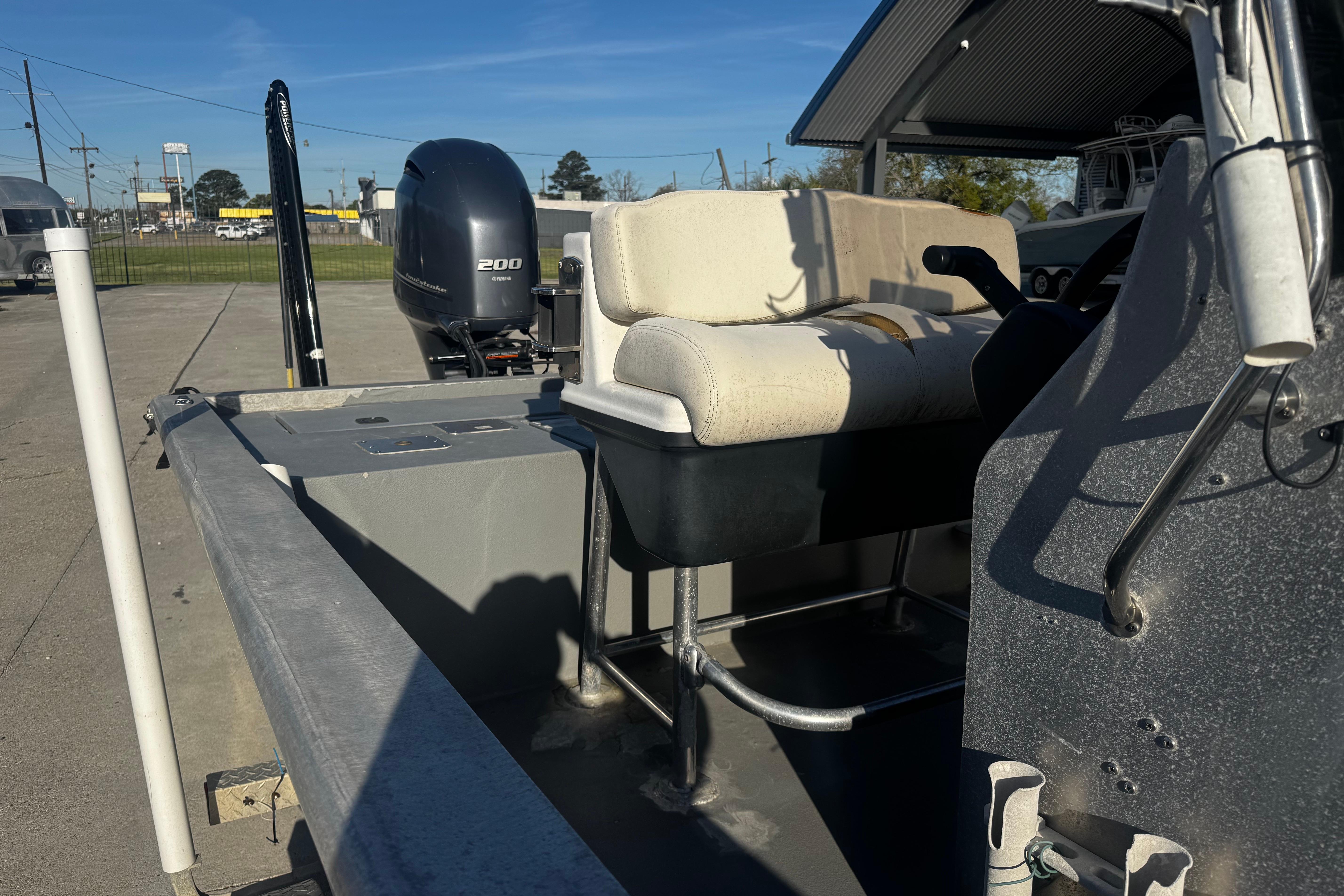 Custom Charles Leonard 21 boat, 2004 model, with Yamaha 200 engine, parked outdoors.
