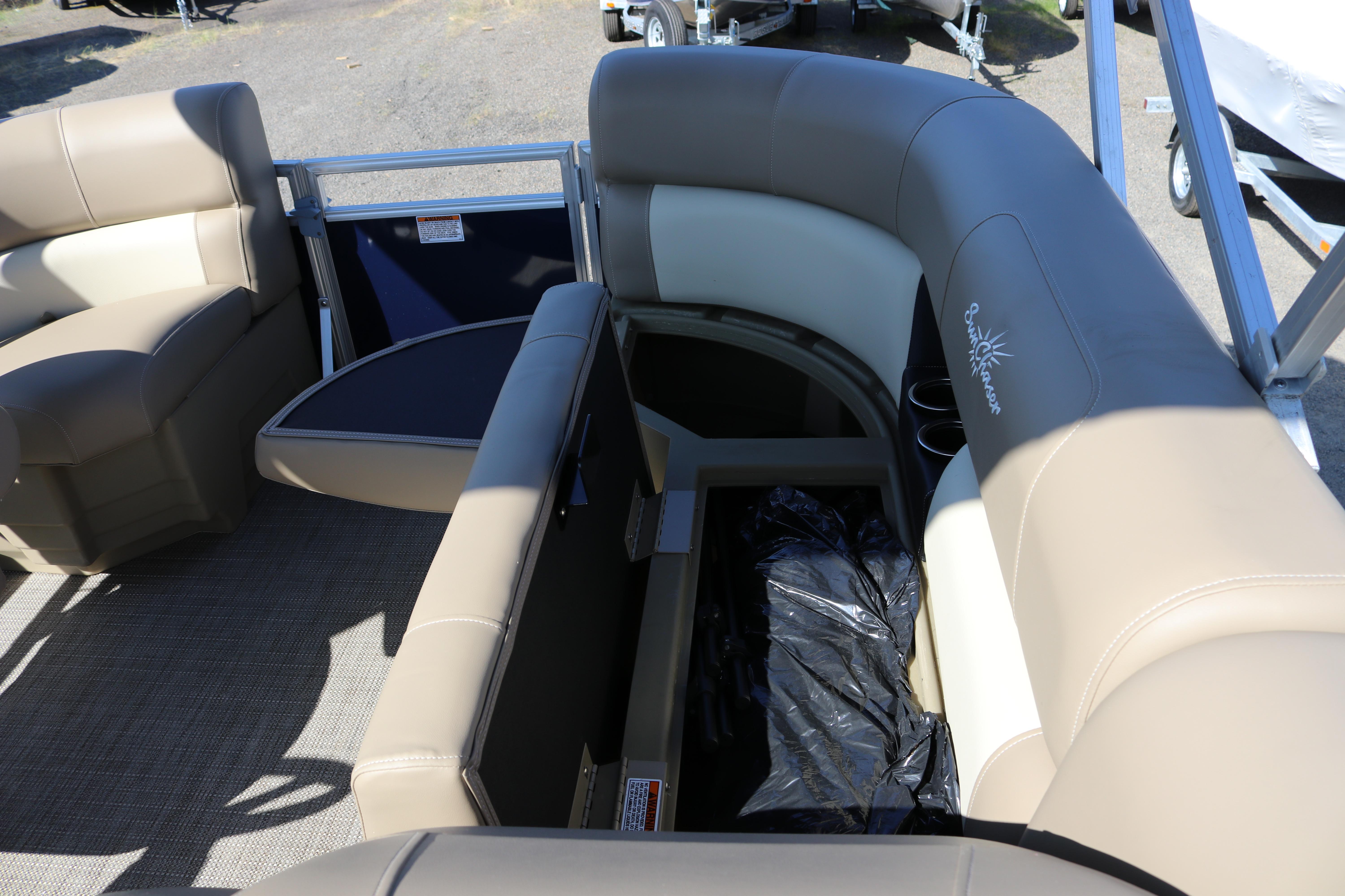 2025 Sun Chaser Vista Fish 18 pontoon boat interior with beige seating and storage compartment.
