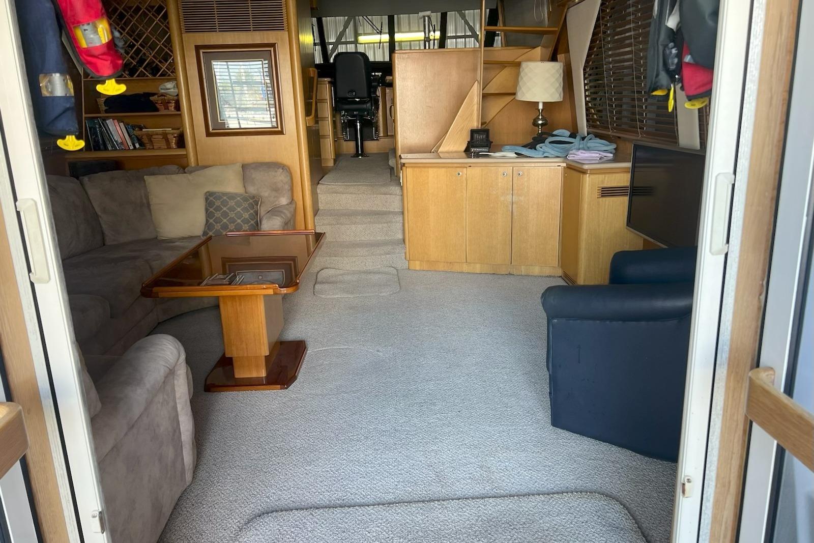 Interior of a 1998 West Bay 58 yacht with cozy seating and wooden cabinetry.