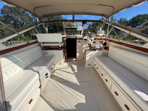 The image shows the cockpit of a 1985 Viking 35 Express with white seating and wood accents.