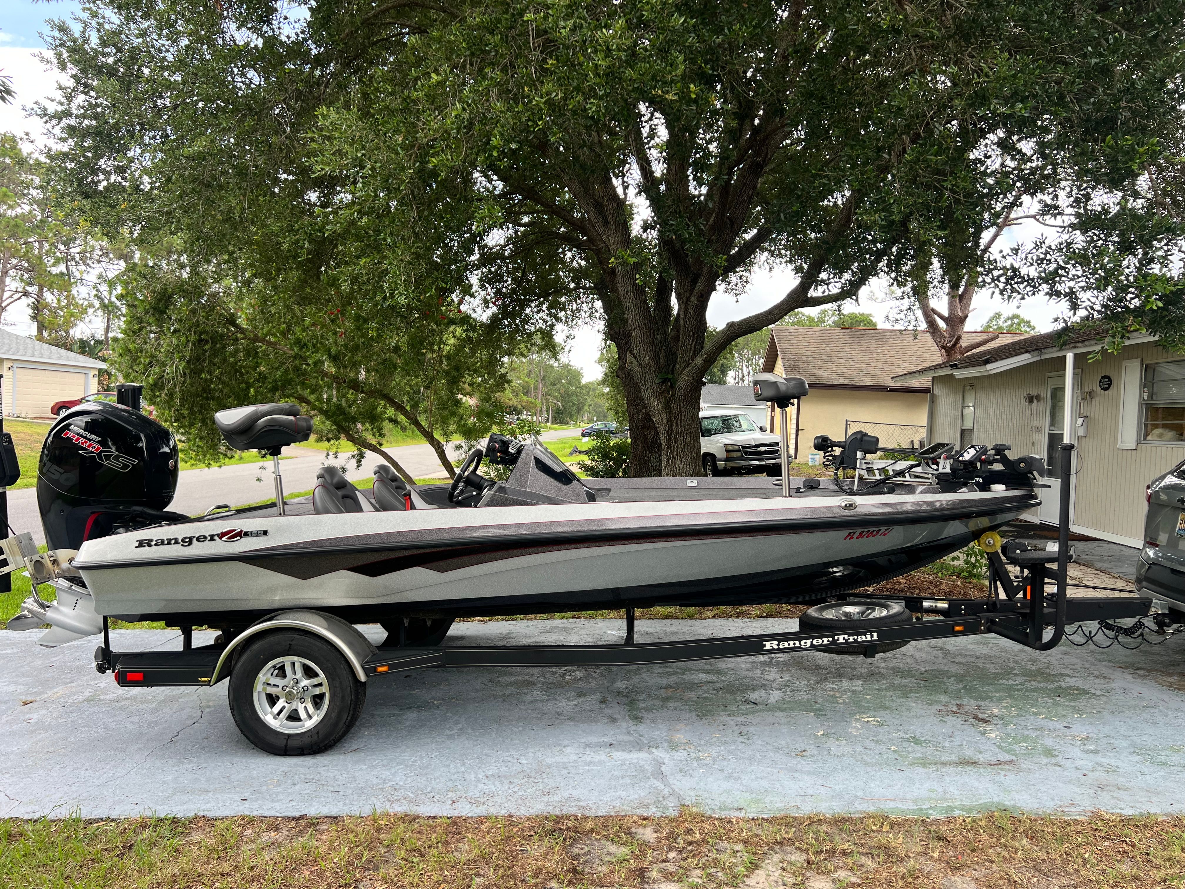2022 Ranger Z185 boat on trailer parked under trees.