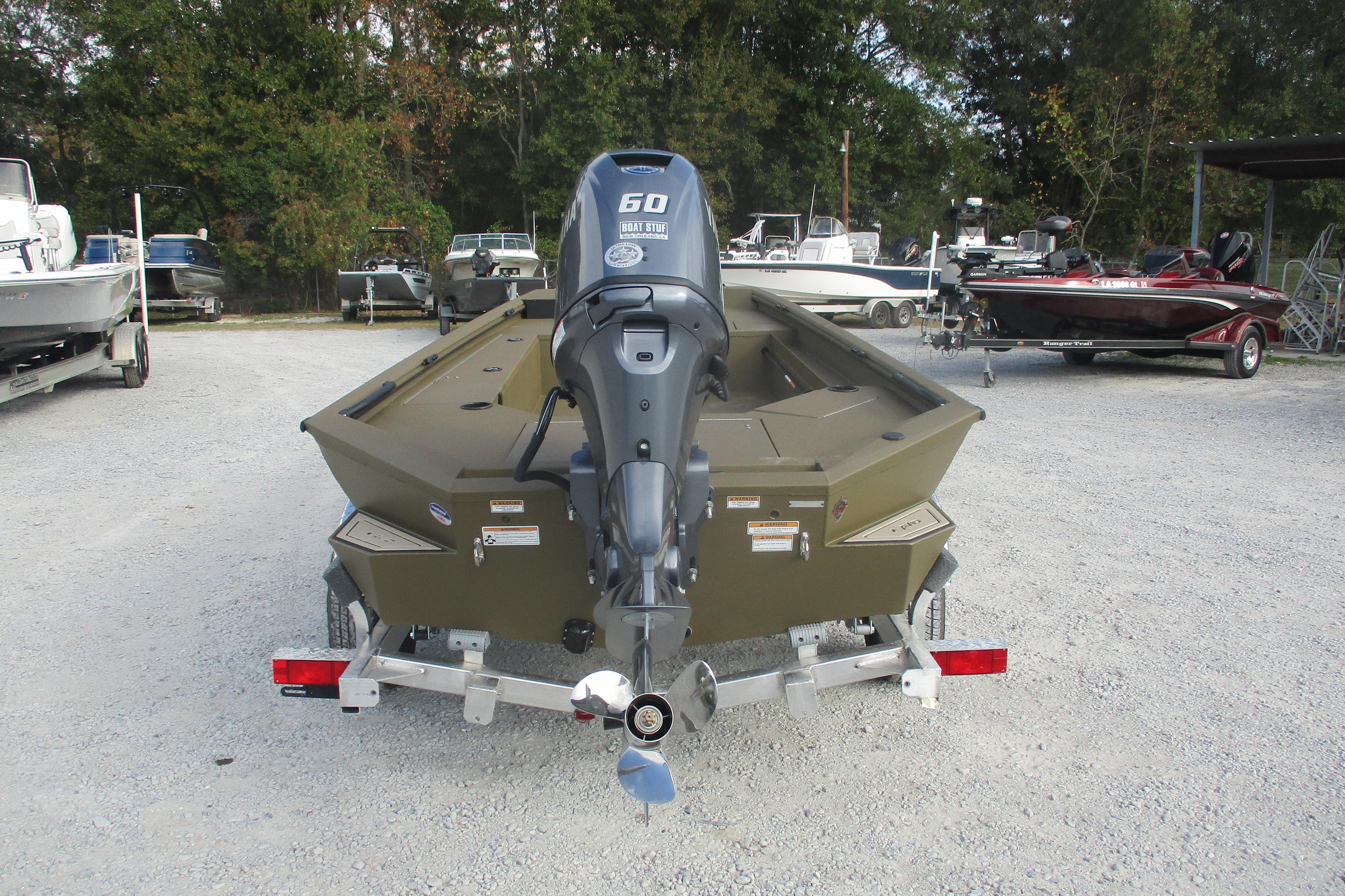 Avid 16 Commander 2026 boat with outboard motor in a parking lot.