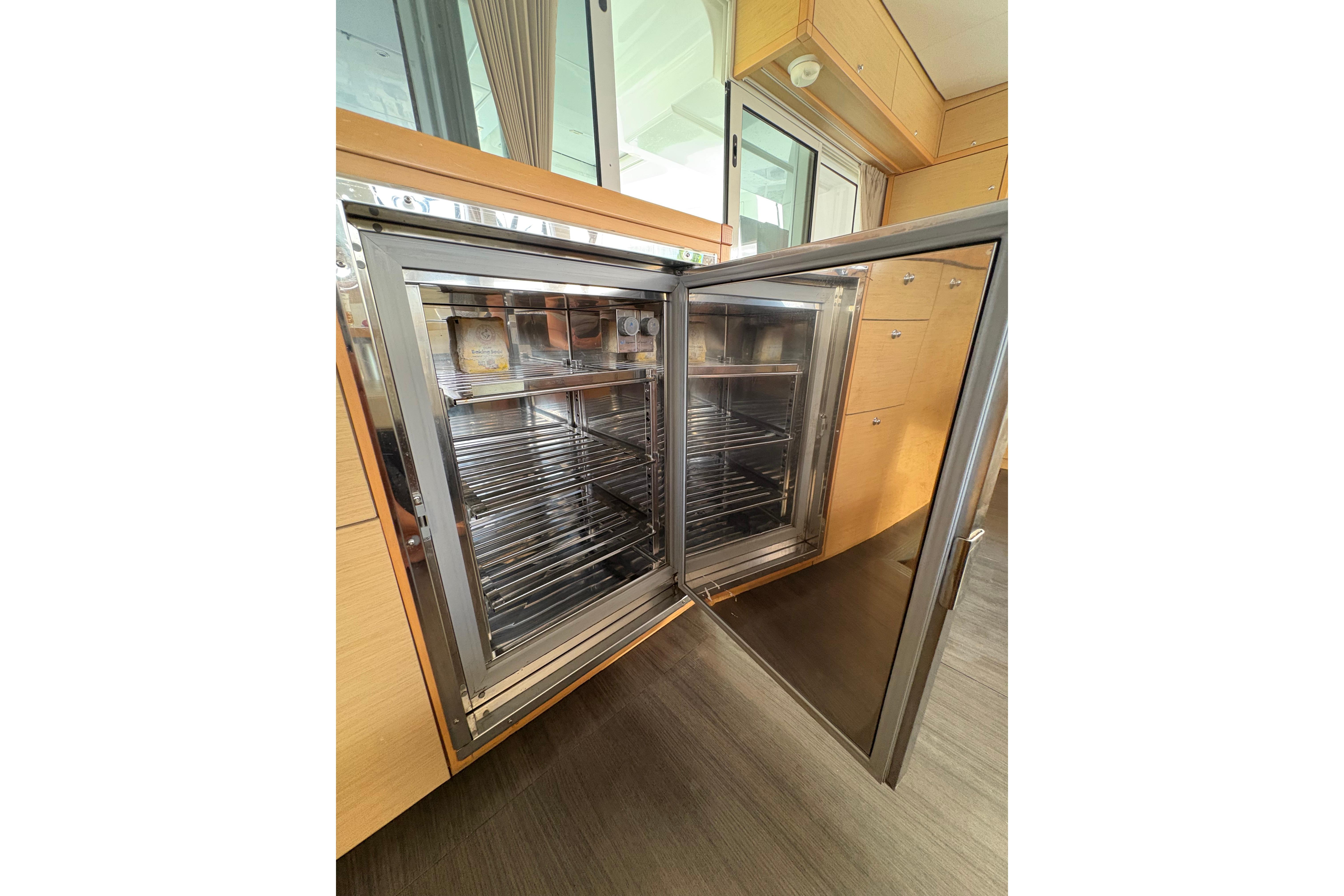 Open stainless steel refrigerator inside 2018 Lagoon 450 yacht, showcasing modern interior design.