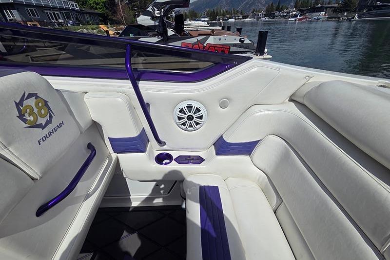 Interior of a 2004 Fountain 38 Lightning boat with white and purple seating.