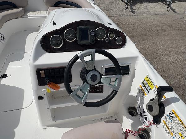 2014 Hurricane SunDeck Sport 232 OB boat dashboard with steering wheel and gauges.