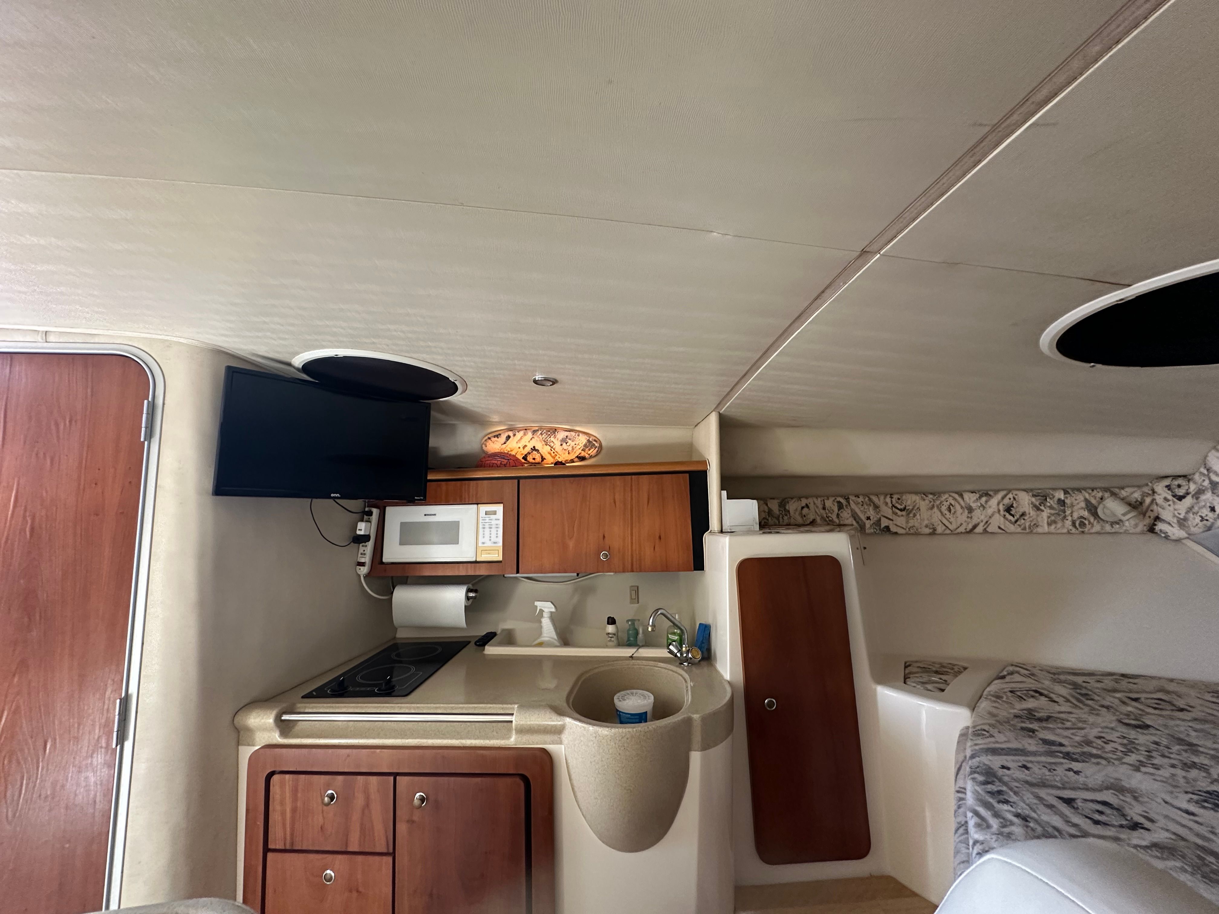 Interior of a 1999 Wellcraft 3000 Matrinique yacht with kitchen and bed.