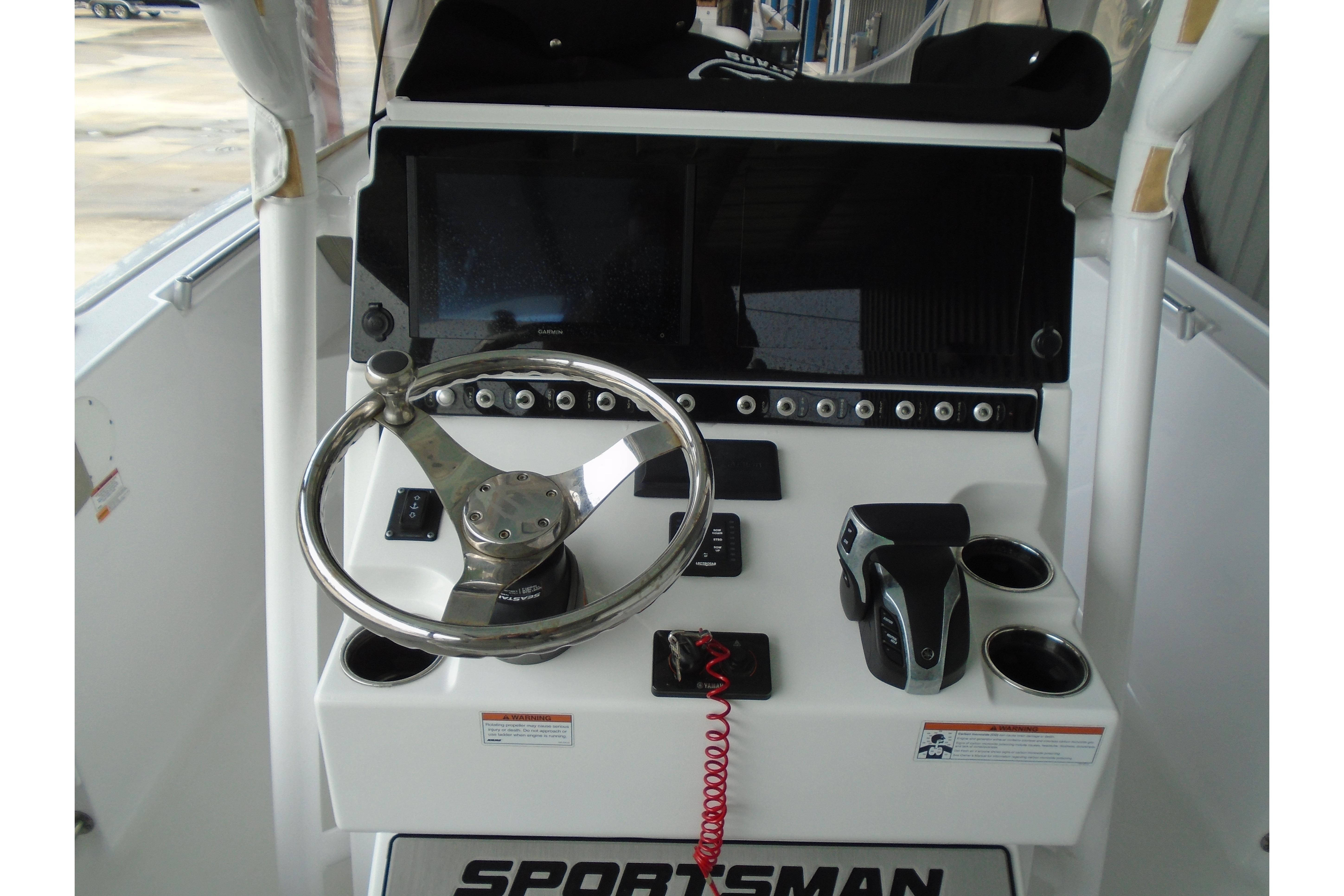 Center console of 2022 Sportsman Heritage 241 boat with steering wheel and controls.