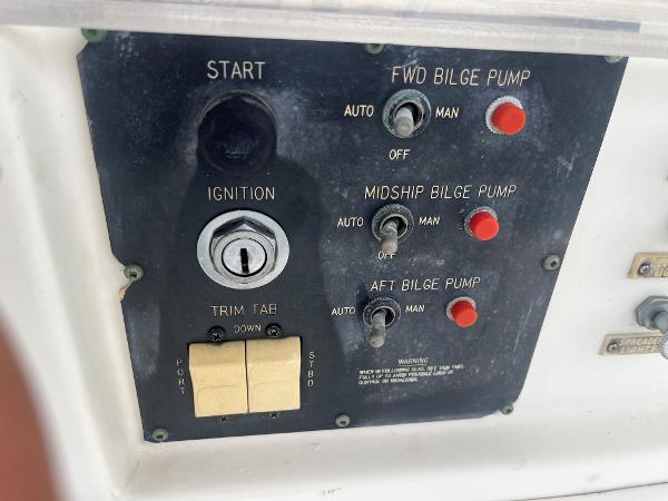Control panel of 1985 Hatteras 45 Convertible boat with ignition and bilge pump switches.