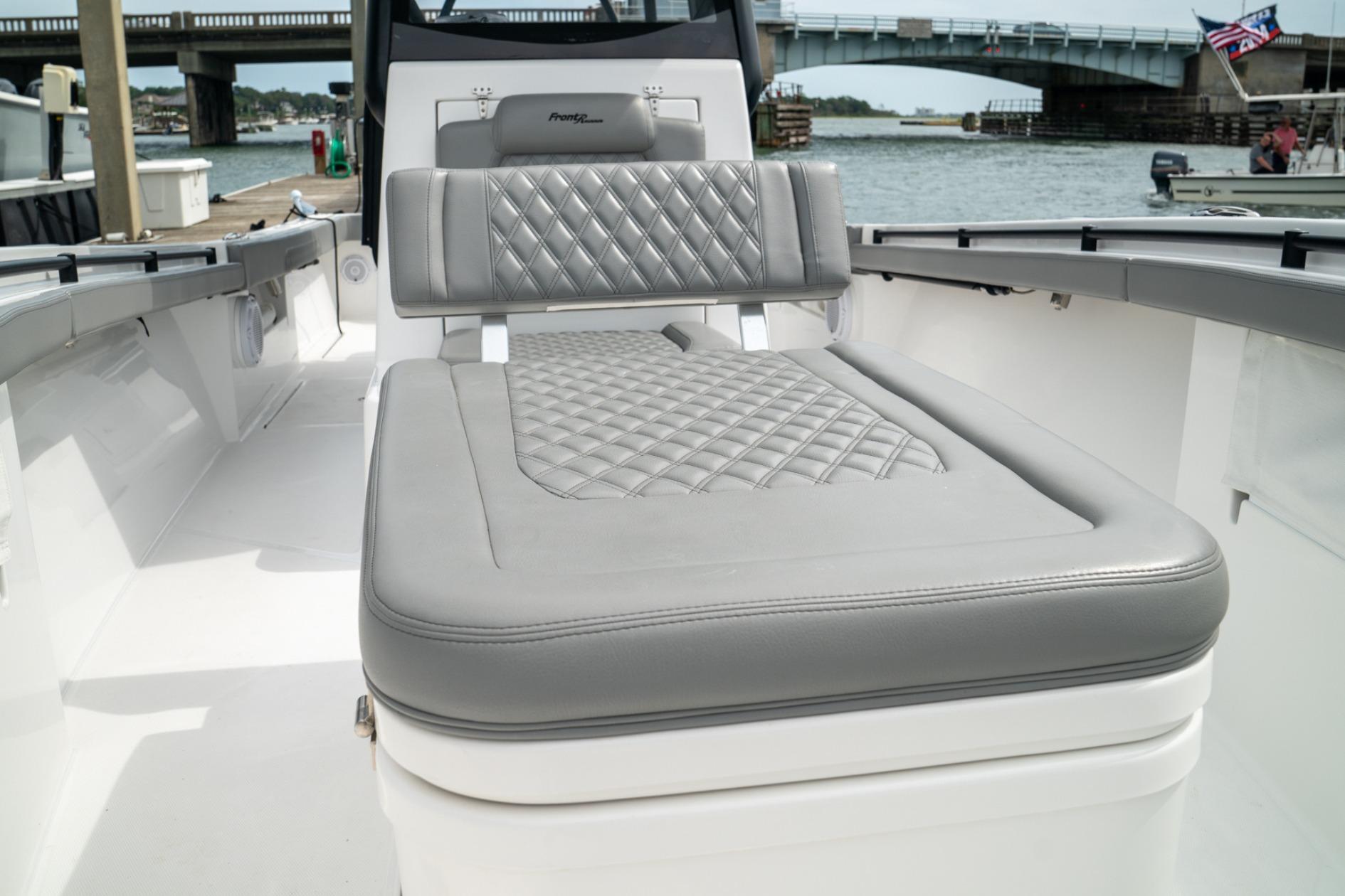 2026 Front Runner 33' Center Console boat with luxurious gray seating, docked near a bridge.